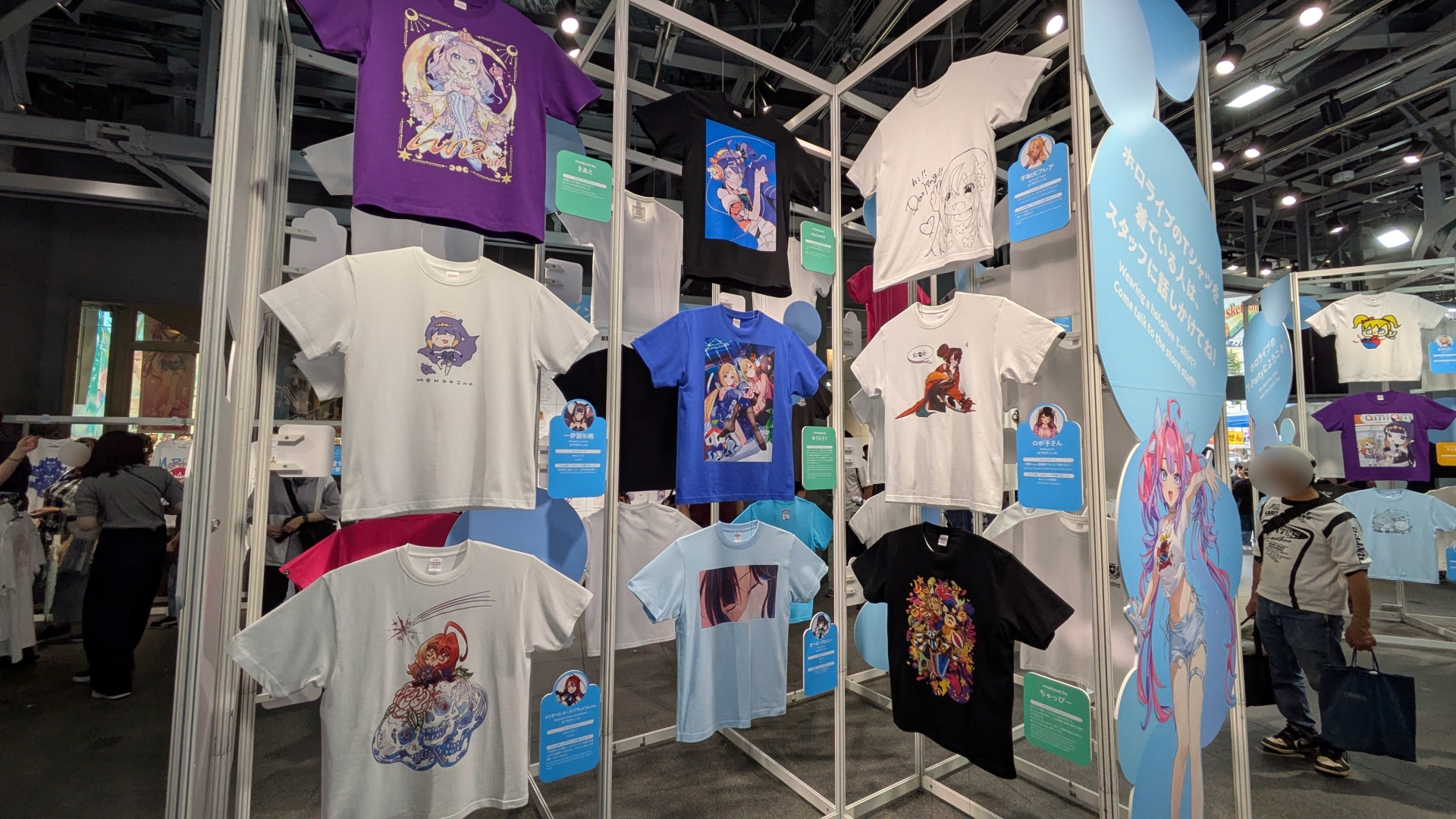 整然と並ぶ種々の「hololive Splash T-Party!」Tシャツ。デザインとコメントなど見どころが多い