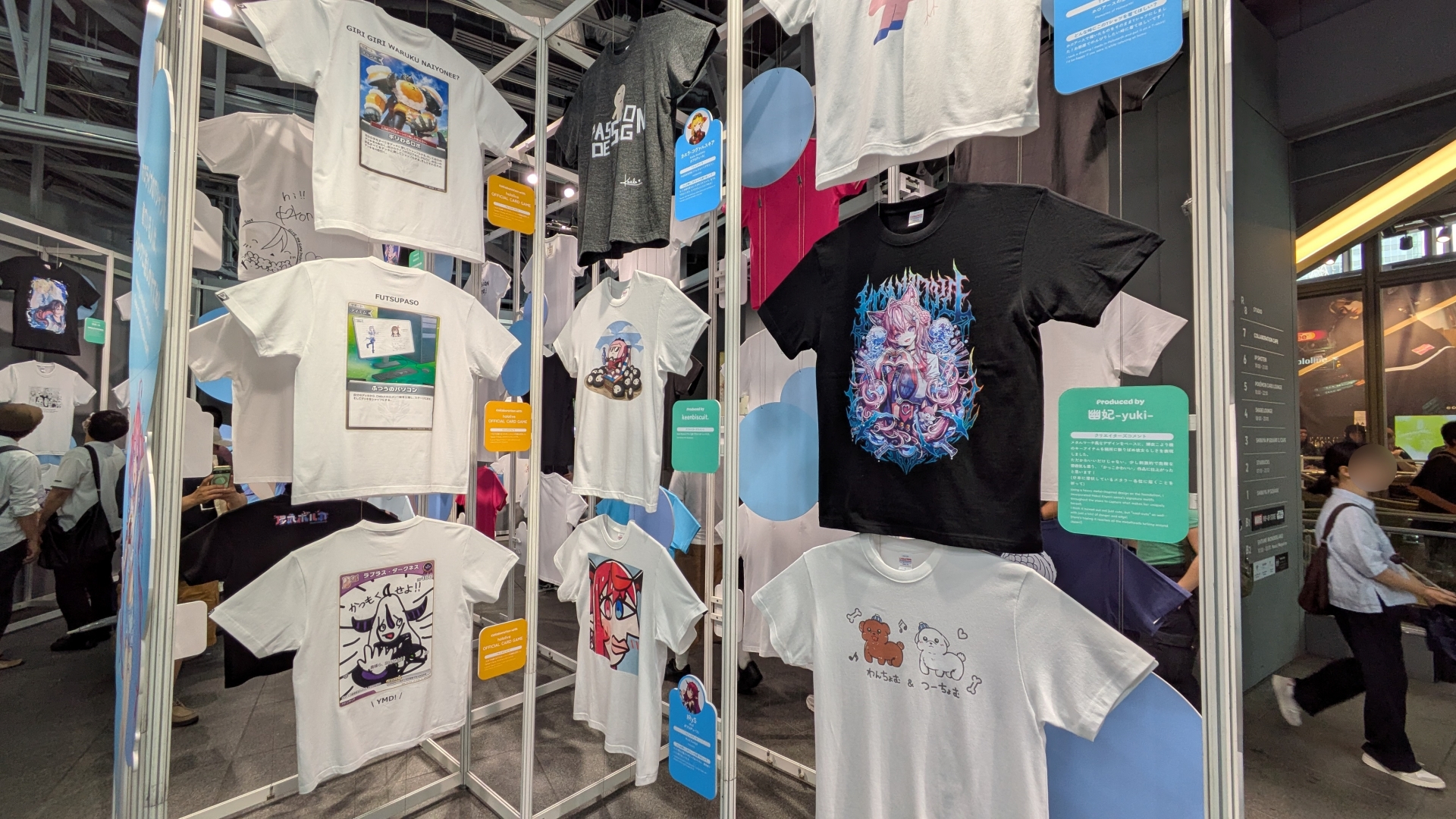 整然と並ぶ種々の「hololive Splash T-Party!」Tシャツ。デザインとコメントなど見どころが多い