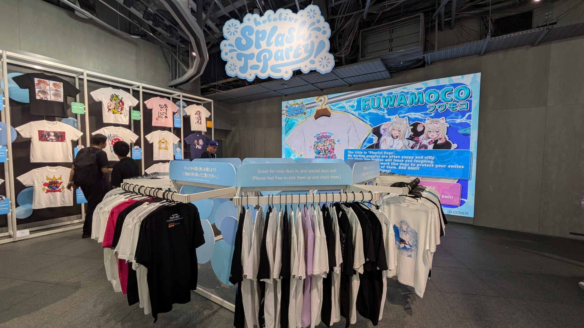 整然と並ぶ種々の「hololive Splash T-Party!」Tシャツ。デザインとコメントなど見どころが多い