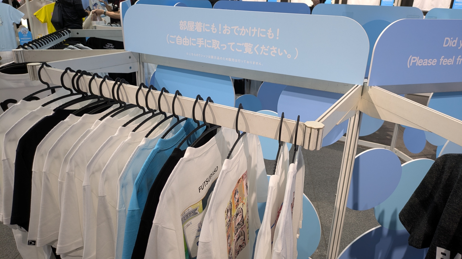 整然と並ぶ種々の「hololive Splash T-Party!」Tシャツ。デザインとコメントなど見どころが多い
