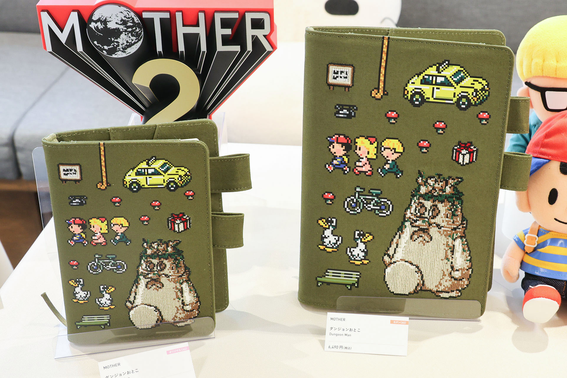 手帳カバーの「MOTHER ダンジョンおとこ」。オリジナル（A6）が5,390円、カズン（A5）が6,490円だ
