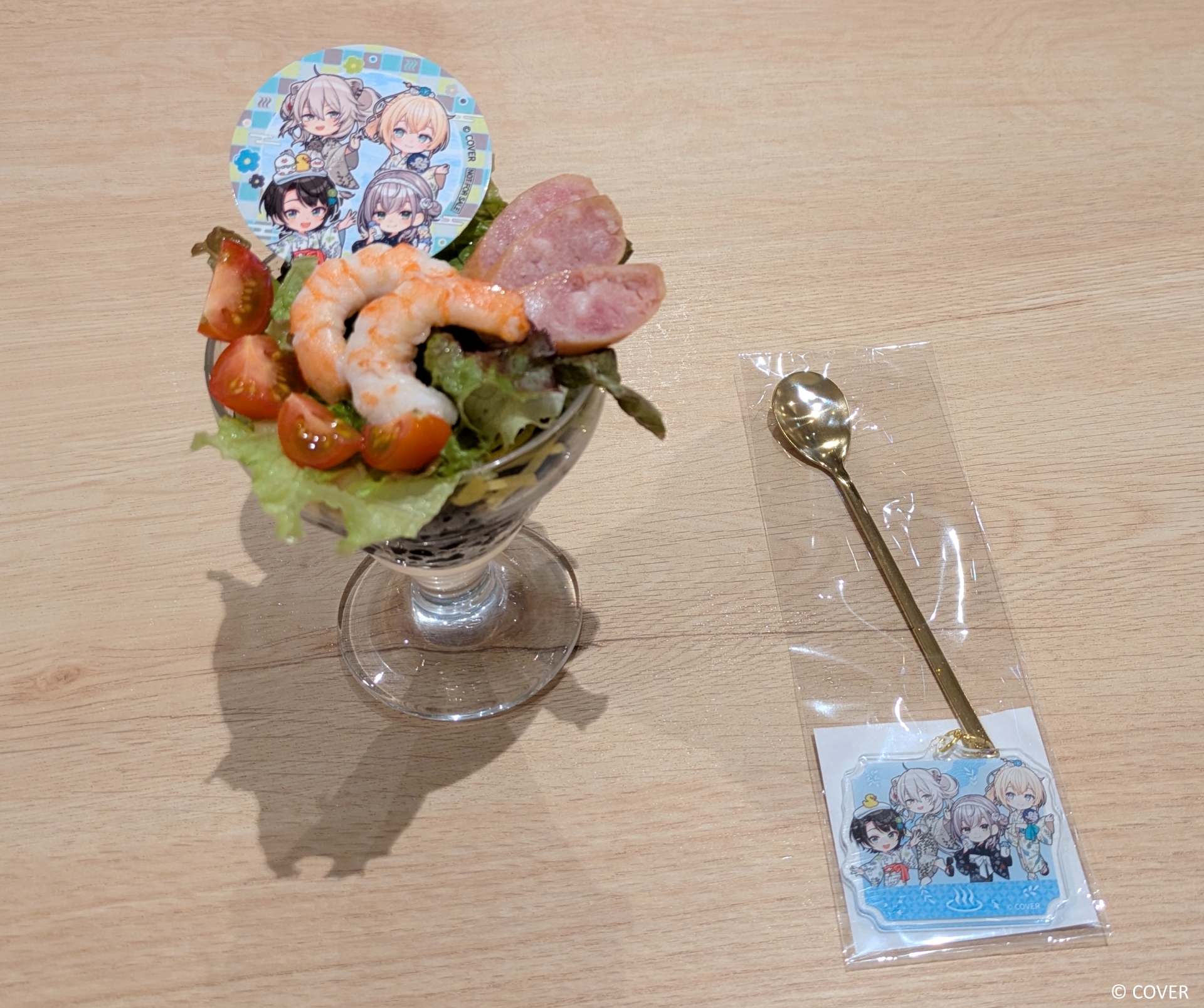 「あなたへ捧げるスペシャル寿司パフェ」（2,530円）。こちらは数量限定でチャーム付きのスプーンが付属する。黒い米にサラダ、エビ、トマト、ソーセージなどがトッピングされたメニューで、もっちりとした米とサラダの組み合わせによる不思議な食感を味わえる