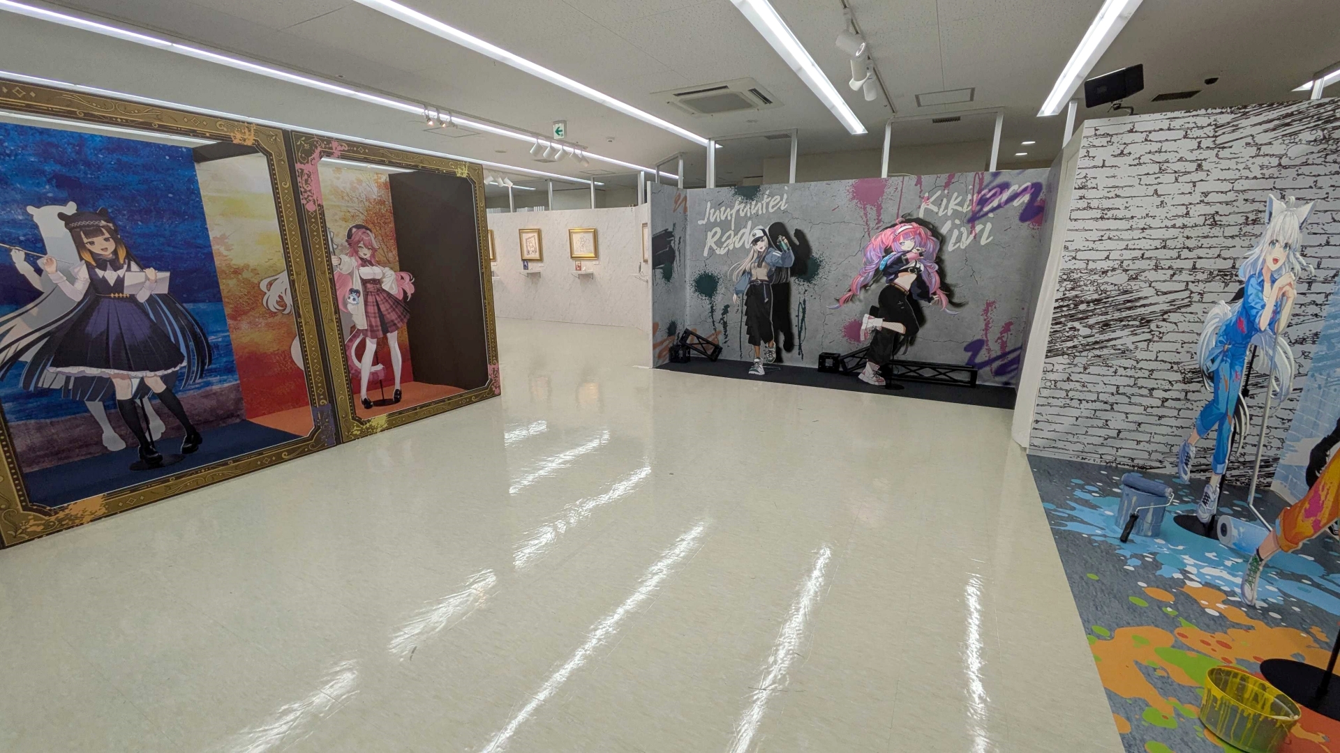 広々とした空間に、共通テーマで分けられた9名のスタンディパネルが背景付きで鎮座している