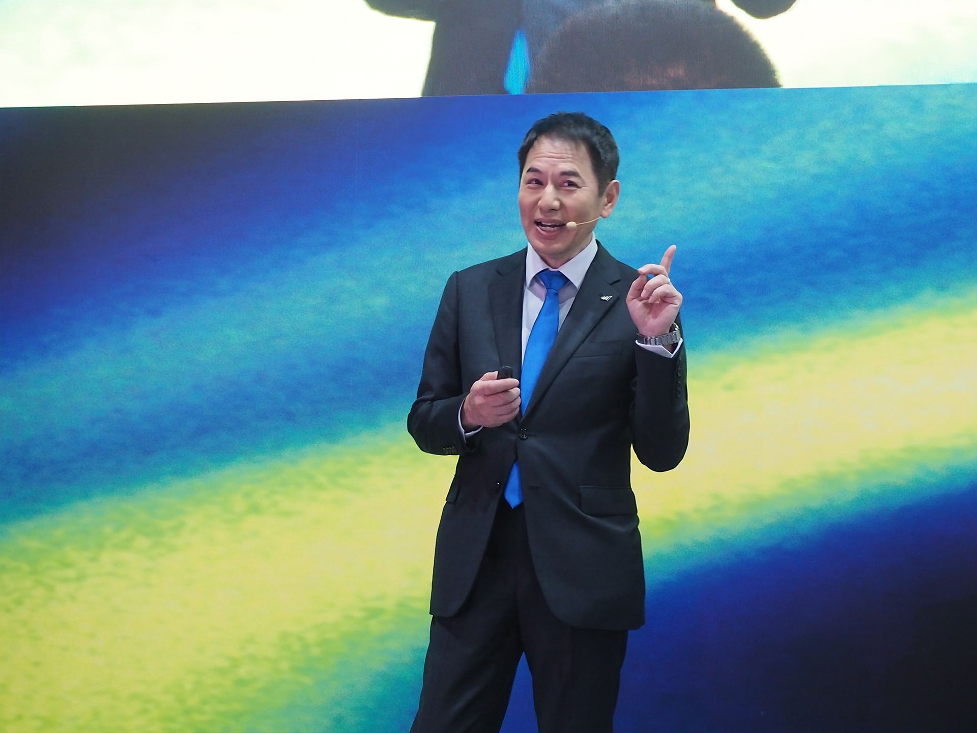 茶目っ気たっぷりに指でもうひとつというサインをする永井氏