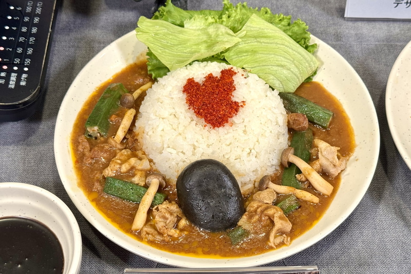 しゃぶ用のコースに含まれる食べ放題食材を組み合わせて作るアレンジメニュー。ご飯＋特製カレー＋お好きな野菜＋ゴジラ風 漆黒のチーズ団子+サラダ用レタス＋一味で「ゴジラの足跡カレー」の完成だ