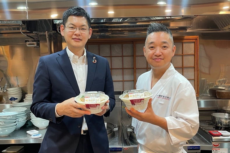 セブン-イレブン・ジャパン 商品本部 地区MD統括部 首都圏担当 マーチャンダイザーの松本正志氏（左）とらぁ麺 飯田商店 店主の飯田将太氏（右）