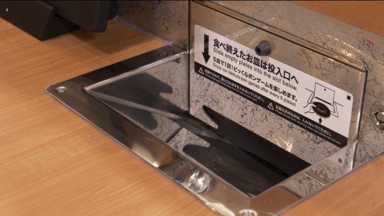 投入口は専用の鍵で小窓を開けられ、店員が皿よりも大きな湯呑みなどを投入して片付けられる構造になっている