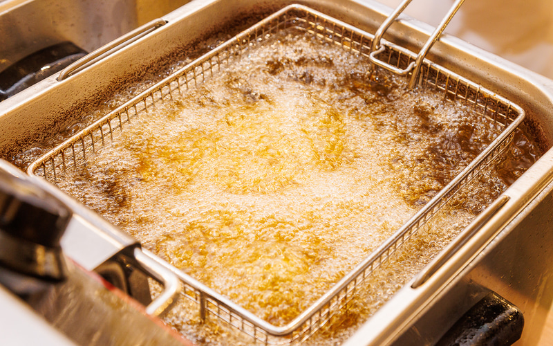 フライヤーの中で鳥モモ肉が踊る