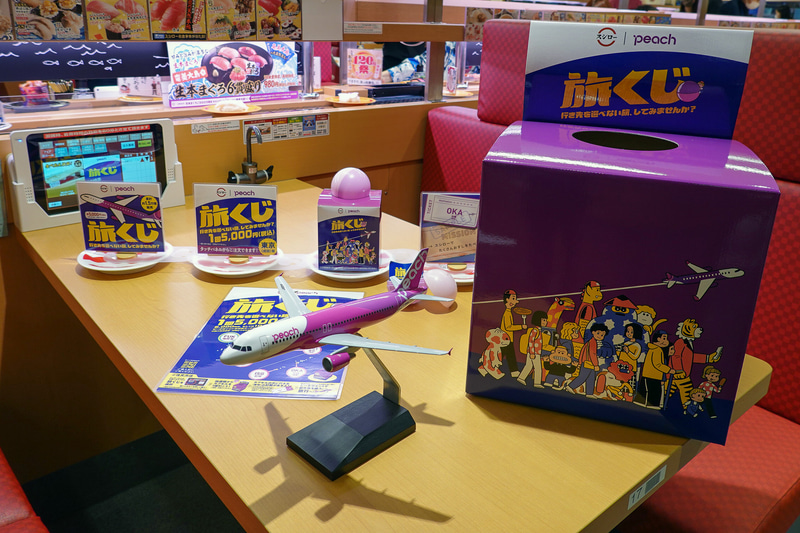 スタッフが持参した「旅くじ」の箱からカプセルを引く