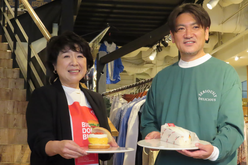コラボメニューを披露するドムドムフードサービス 代表取締役の藤﨑忍氏（左）とアダストリア 執行役員 ニコアンド営業本部長の星野明氏（右）