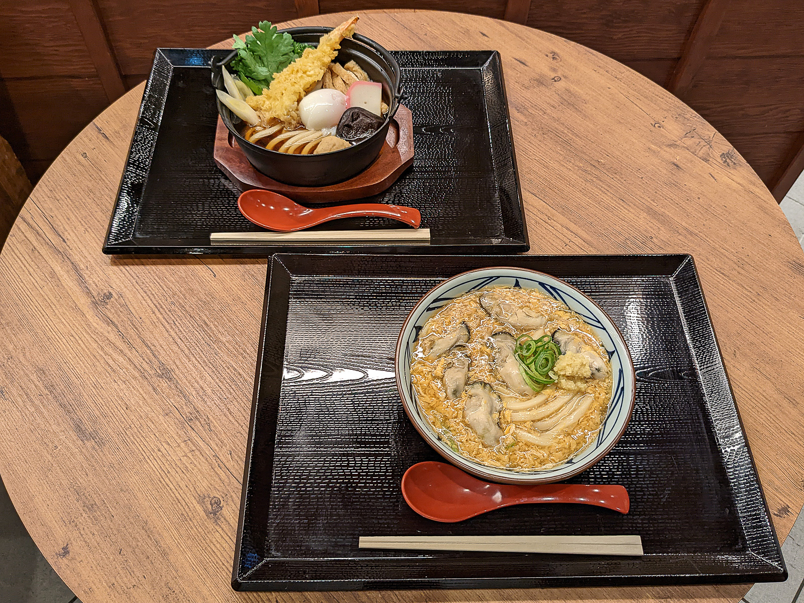 丸亀製麺「牡蠣たまあんかけうどん」（手前）と「鍋焼きうどん」（奥）