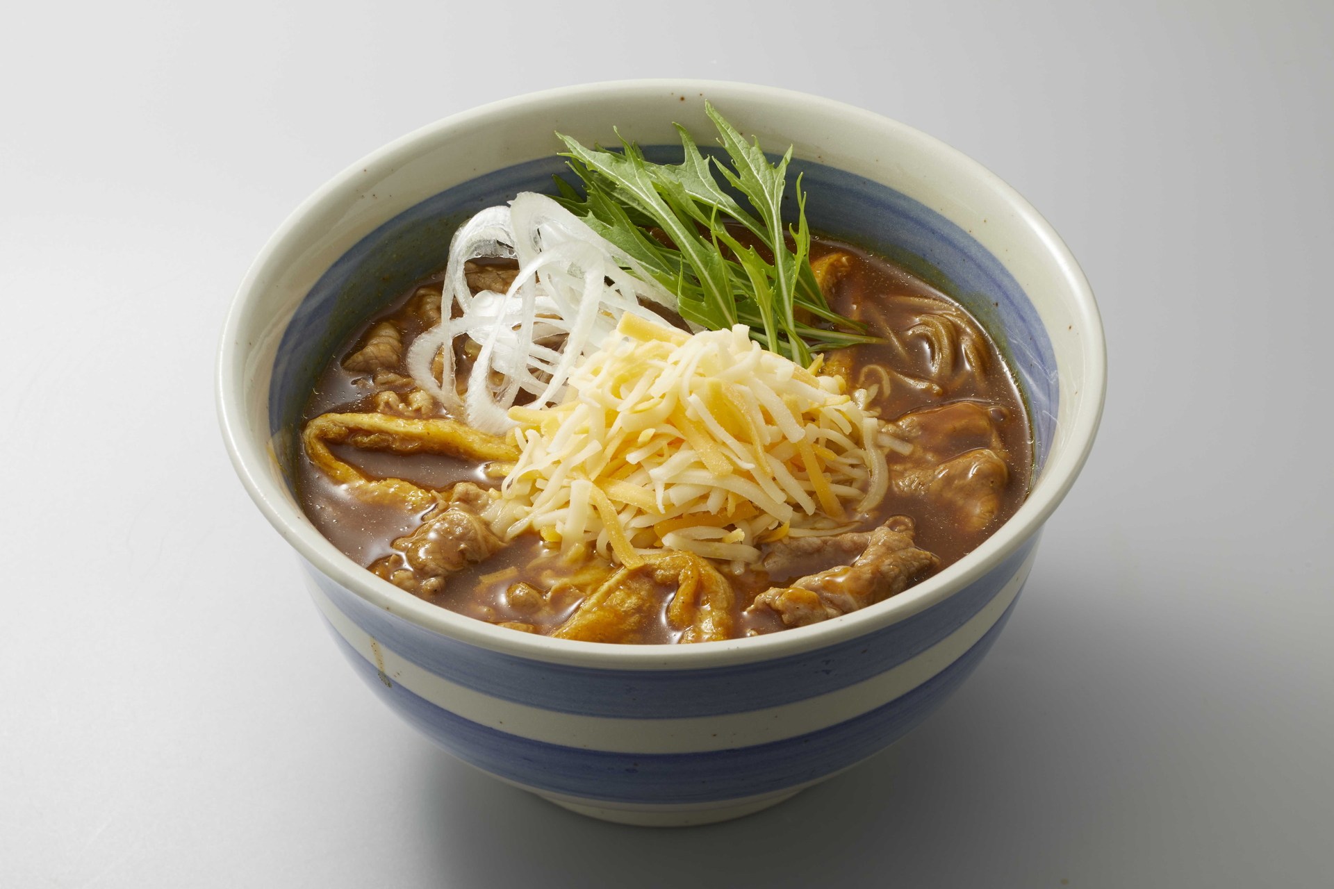 6種類のスパイスにかつお・昆布・帆立の和風だしのカレーだしに、たっぷりのとろ～りチーズとねぎをトッピングした「牛肉チーズ水菜カレーNMB（なんばん）そば」