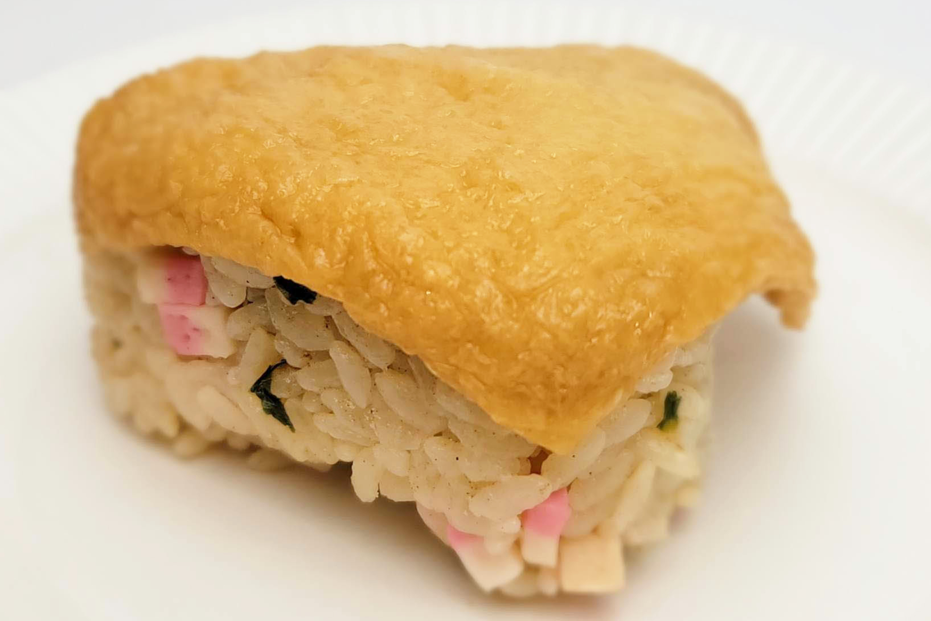 ジューシーなおあげに、だしの効いた炊き込みご飯。「どん兵衛」でおなじみのピンクのかまぼこ入りだ