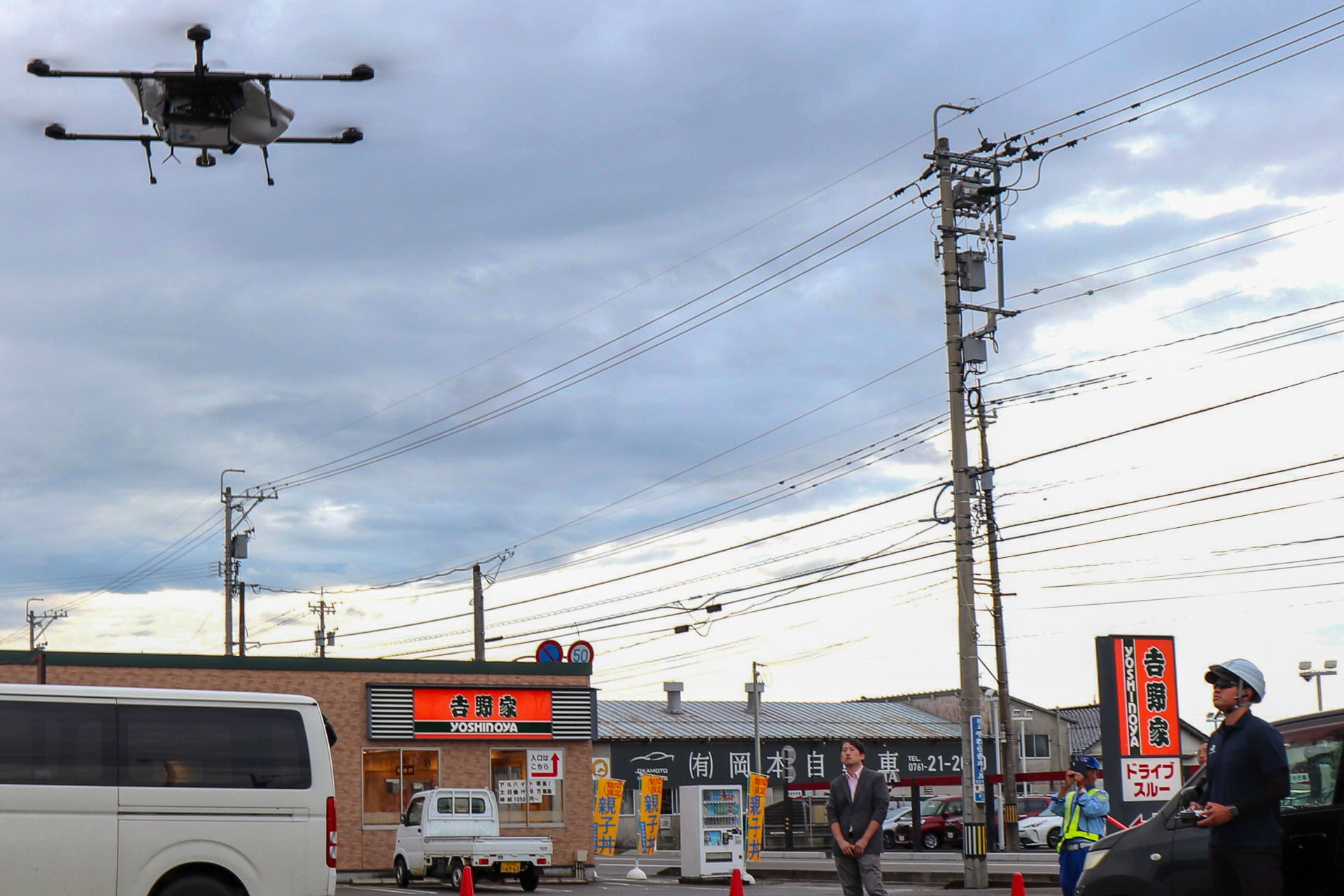 吉野家小松店駐車場から牛丼弁当を載せて離陸する物流専用ドローン「AirTruck」