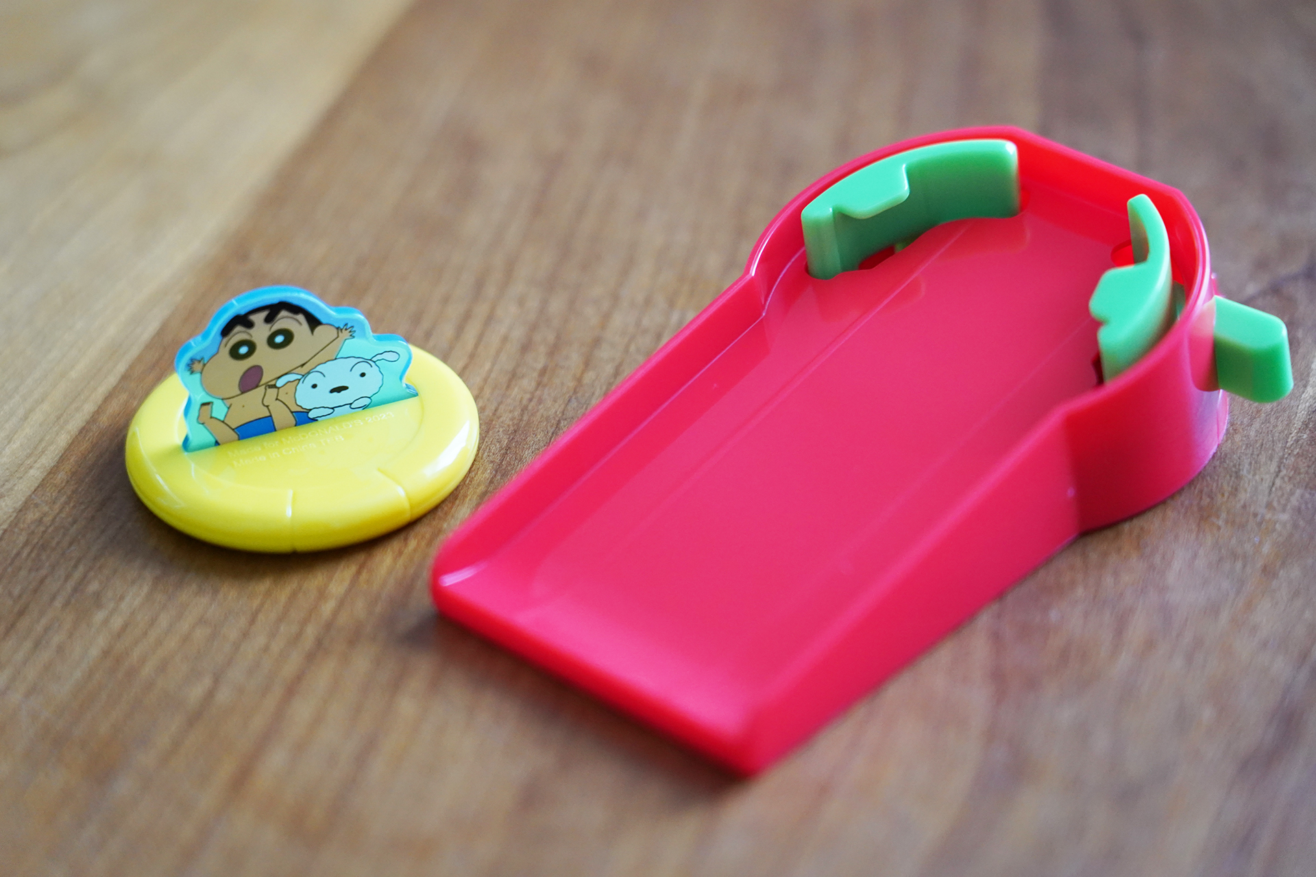 浮き輪に乗ったしんちゃんとシロがウォータースライダーで遊んでいる