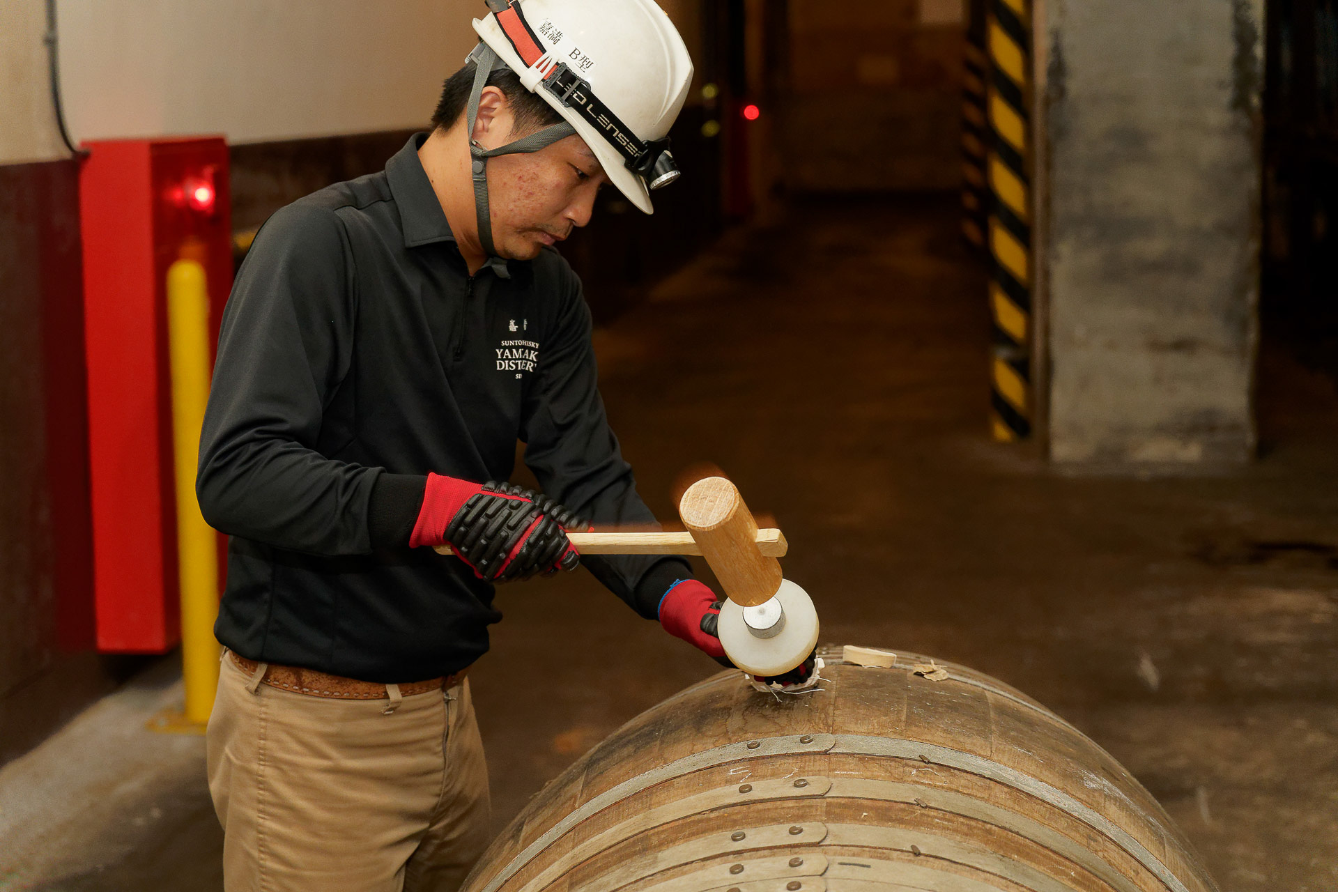 サンプリング作業の実演。木槌とノミで木栓を削り取っていく
