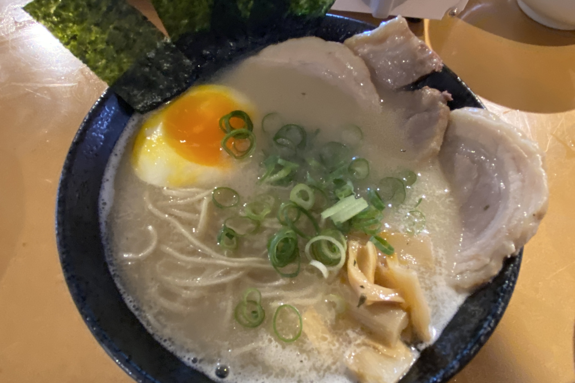 豚骨の食欲をそそる香りが作っているそばからただよう。好みでコショウをかけて味変できる