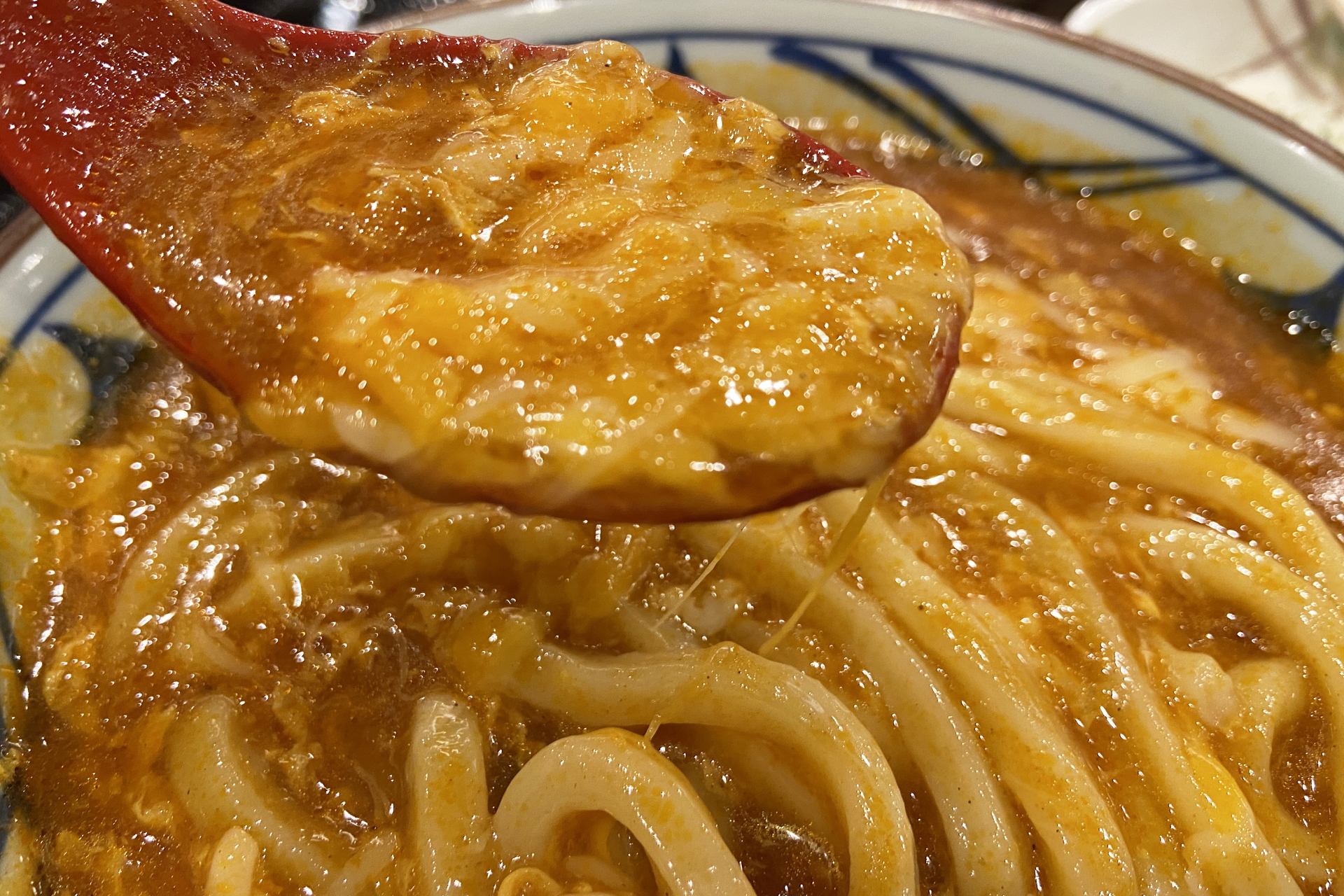 ガツンと旨辛いトマたまカレーうどんにまろやかなチーズの相性抜群で、麺をすする手が止まらない