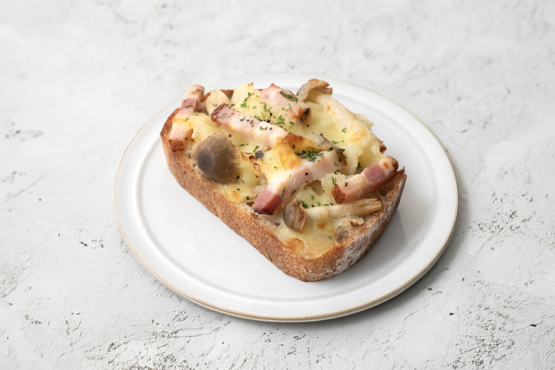 「自家製ベーコンとじゃがいもとキノコのチーズオープンサンド」（323円）