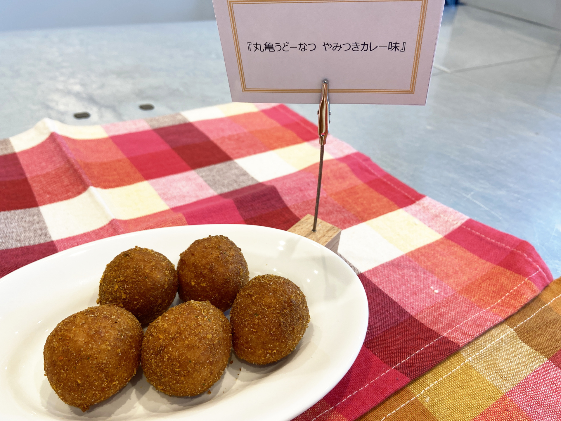 「丸亀うどーなつ やみつきカレー味」は複数のスパイスにフライドオニオン、ガーリックの旨味を加えたスパイシーなクセになる味わい