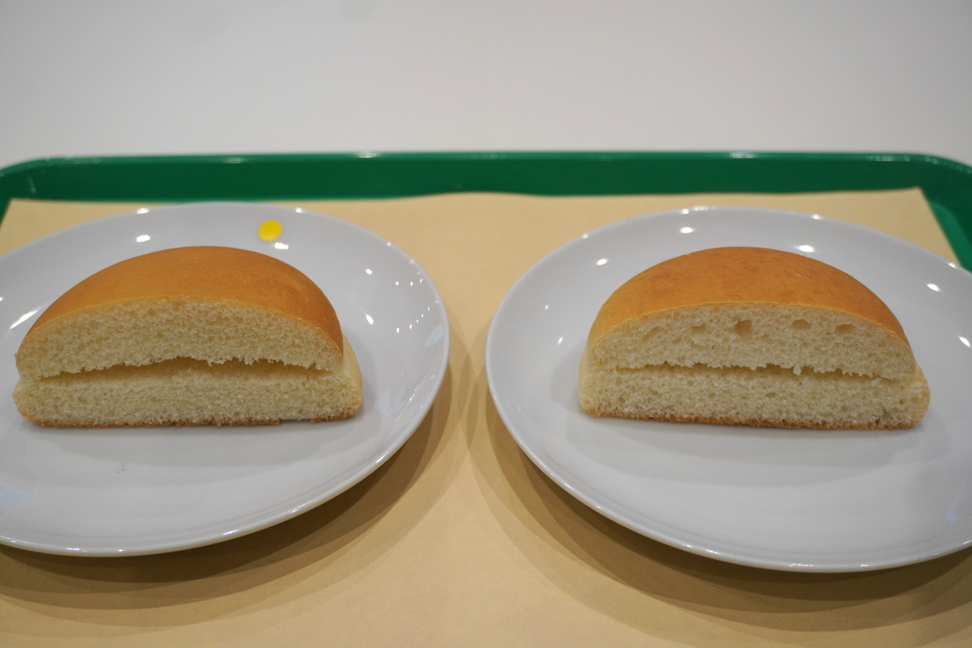 麩切りをした通常バンズ（黄色いシールが付いた左）、麩切りをしなかったバンズ（右）。