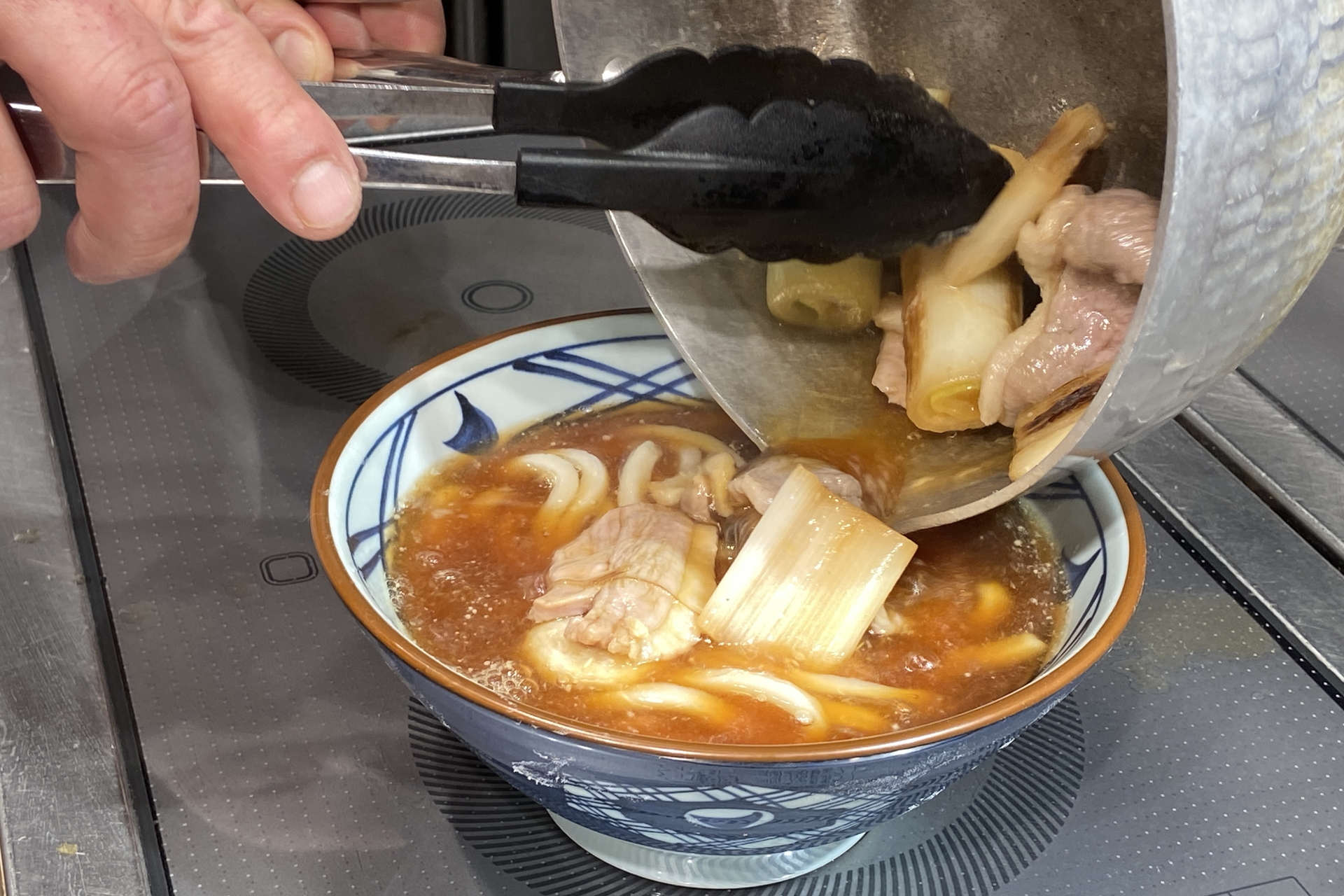 白だしに特製のかえしを合わせ、下味をつけた鴨肉と焼き目をつけた白ねぎをグツグツ煮立たせる。鴨の旨味と脂の甘みが引き立つ味わいに