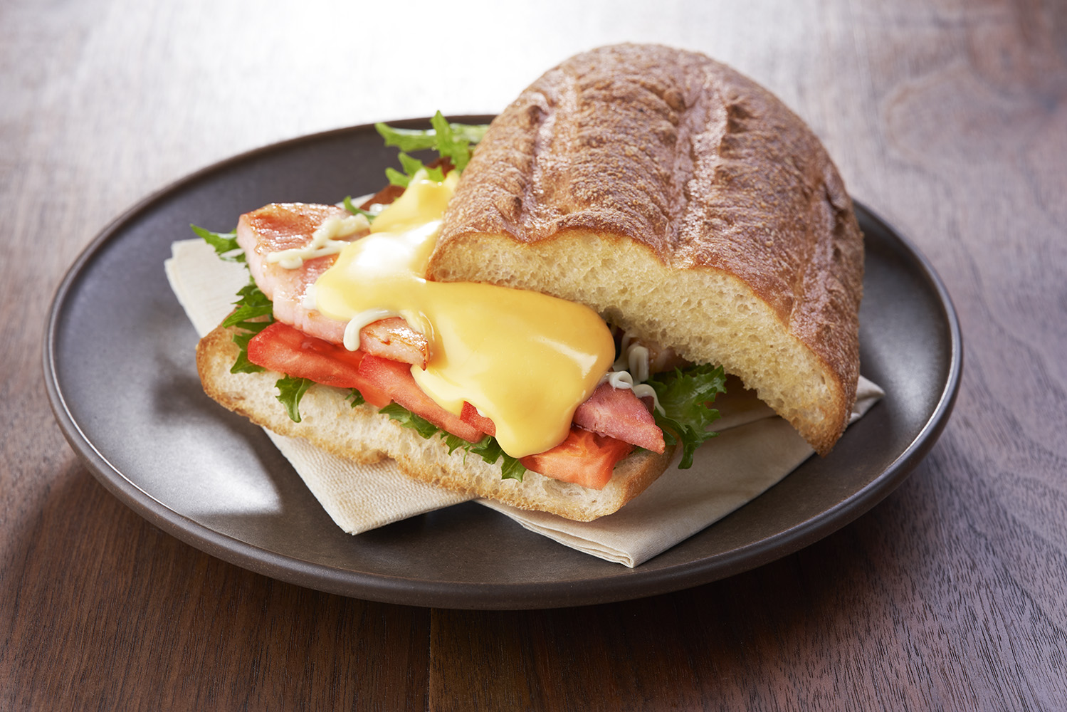 ザクっともっちり生地にジューシーな厚切りベーコンを、フレッシュなトマト・レタスととろ〜りチーズが包み込んだ大満足の「サンマルクホットサンド BLT」（540円～）