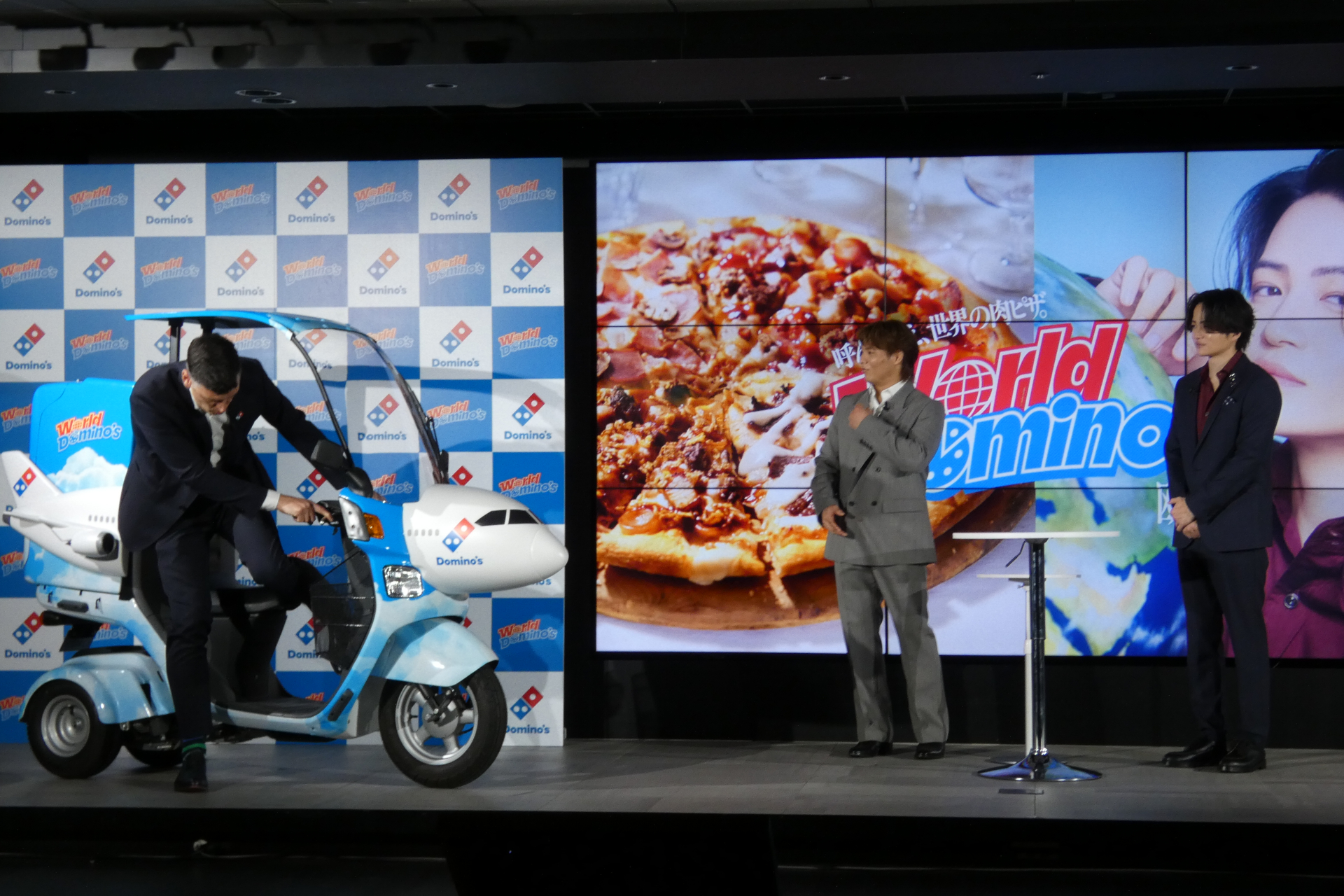 スティーンクス氏がワールドドミノ仕様のバイクで試食用のピザを配達。ちなみに、このバイクは青山店に導入される予定とのこと