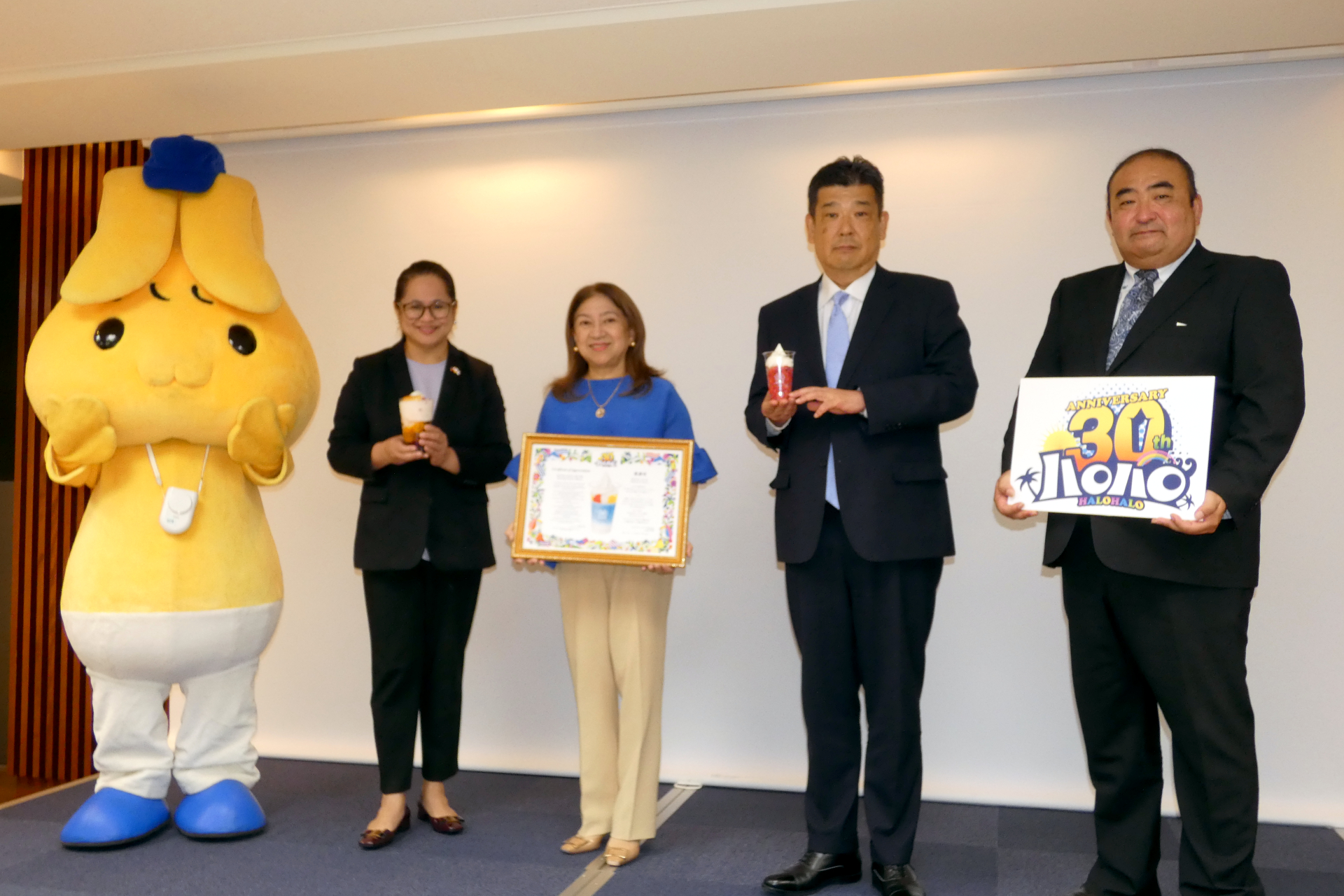 （左から）ミニストップのキャラクター「ミミップくん」、フィリピン大使館 一等書記官兼領事のファティマ・キンティン氏、駐日フィリピン共和国特命全権大使のミレーン・デ・ホヤ・ガルシア=アルバノ閣下、ミニストップ 代表取締役社長の堀田昌嗣氏、取締役ミニストップ事業担当の仲澤光晴氏