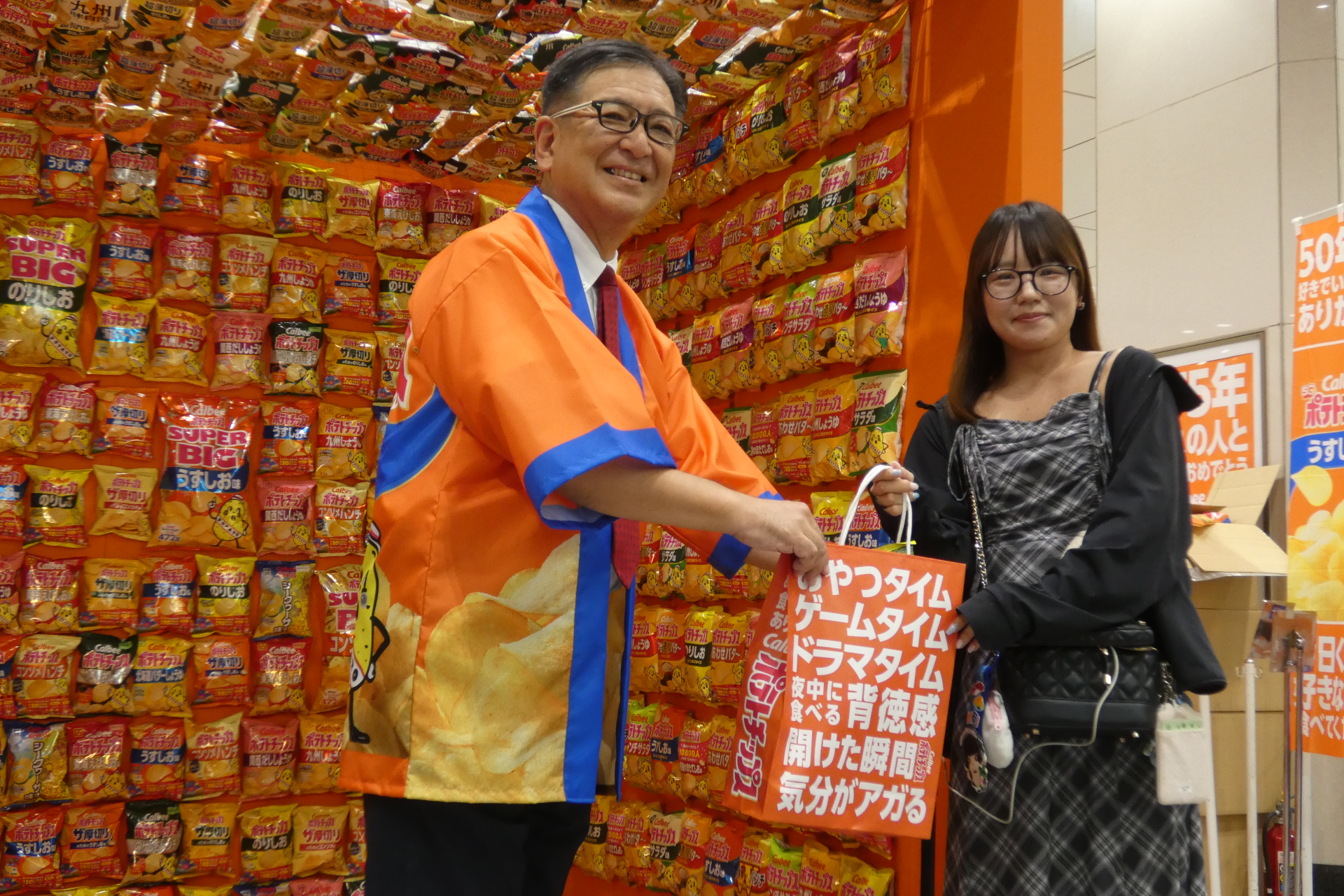 JR東京駅中央口イベントスペースにて来場者に袋を手渡す江原氏