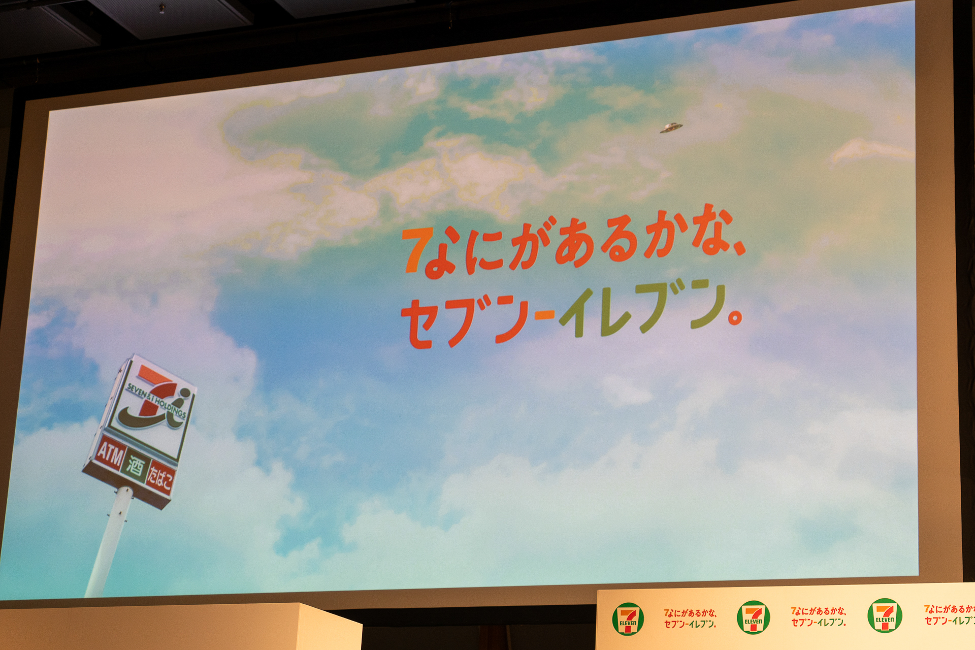 「なにがあるかな、セブン-イレブン。」をコンセプトとする新CMキービジュアル。よく見ると空にUFOが！