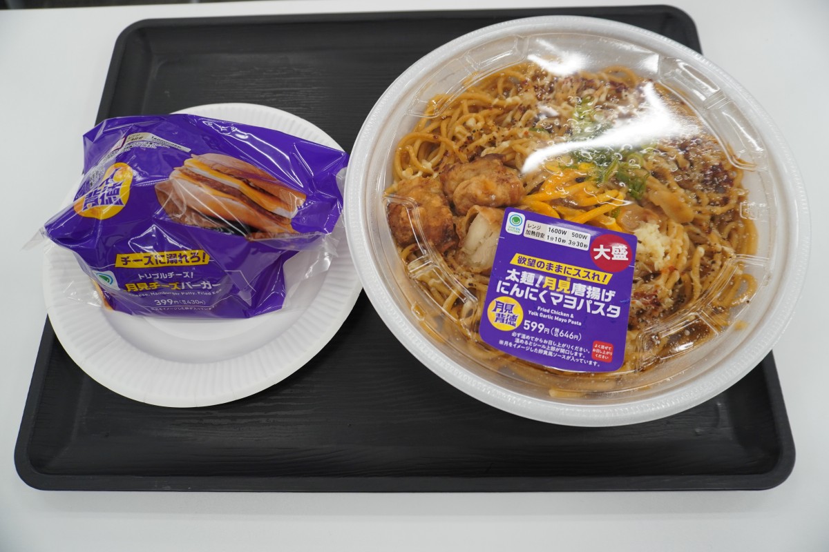 試食で提供された「チーズに溺れろ！月見チーズバーガー」（左）と「大盛太麺！月見唐揚げ にんにくマヨパスタ」（右）