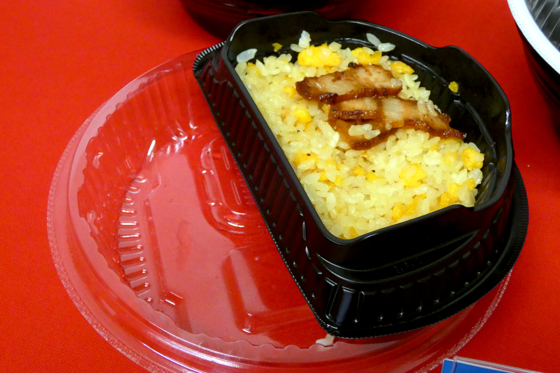 フタにチャーハンの容器を置けば机を汚さずに食べられるほか、大きめの持ち手をつけることで火傷せずに持ち上げられるように工夫されている