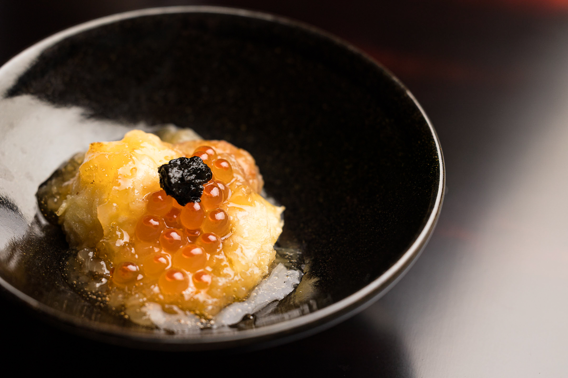 日本料理で研鑽を重ねた料理長が提供する酒肴は、懐石の流れを汲んだ先付けから始まる構成。秋の献立では、身が引き締まった戻り鰹を、かつらむきのように薄く剥いた大根の酢漬けと錦糸卵で巻いた「鰹の巻物」や、旬を迎える「伊勢海老と無花果の揚げ出し」などを提供する