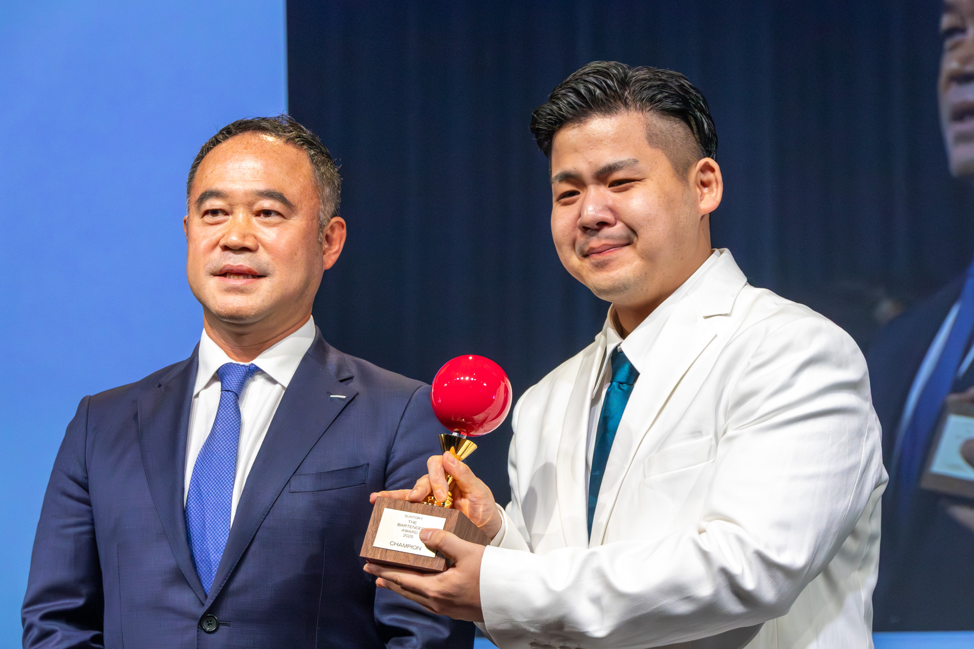 優勝したのは若林将太さん。プレゼンターはサントリー株式会社 執行役員 スピリッツ本部長 塚原大輔氏