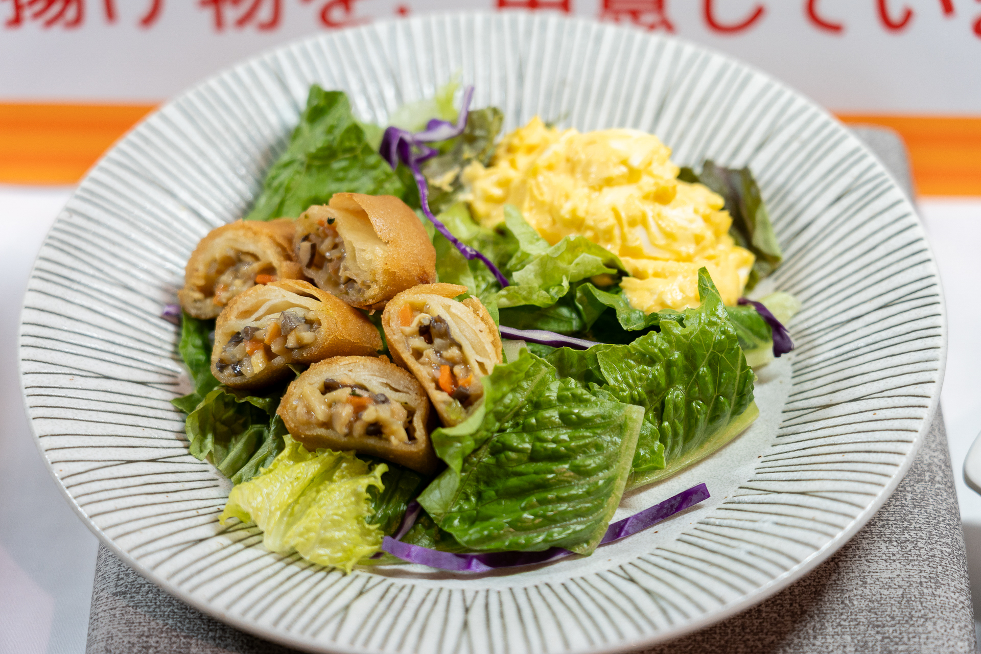 「春巻きのタルタルサラダ」は一口サイズに切った春巻きをレタスサラダとたまごサラダとともに食べるというアレンジ