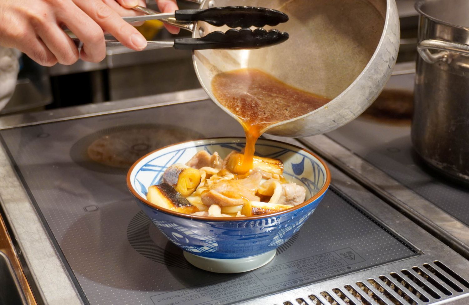 合鴨肉と白ねぎの旨みが溶け込んだ出汁を注ぐ