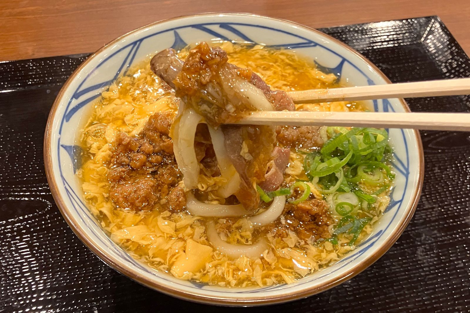 玉子あんと牛肉やそぼろがうどんに絡む