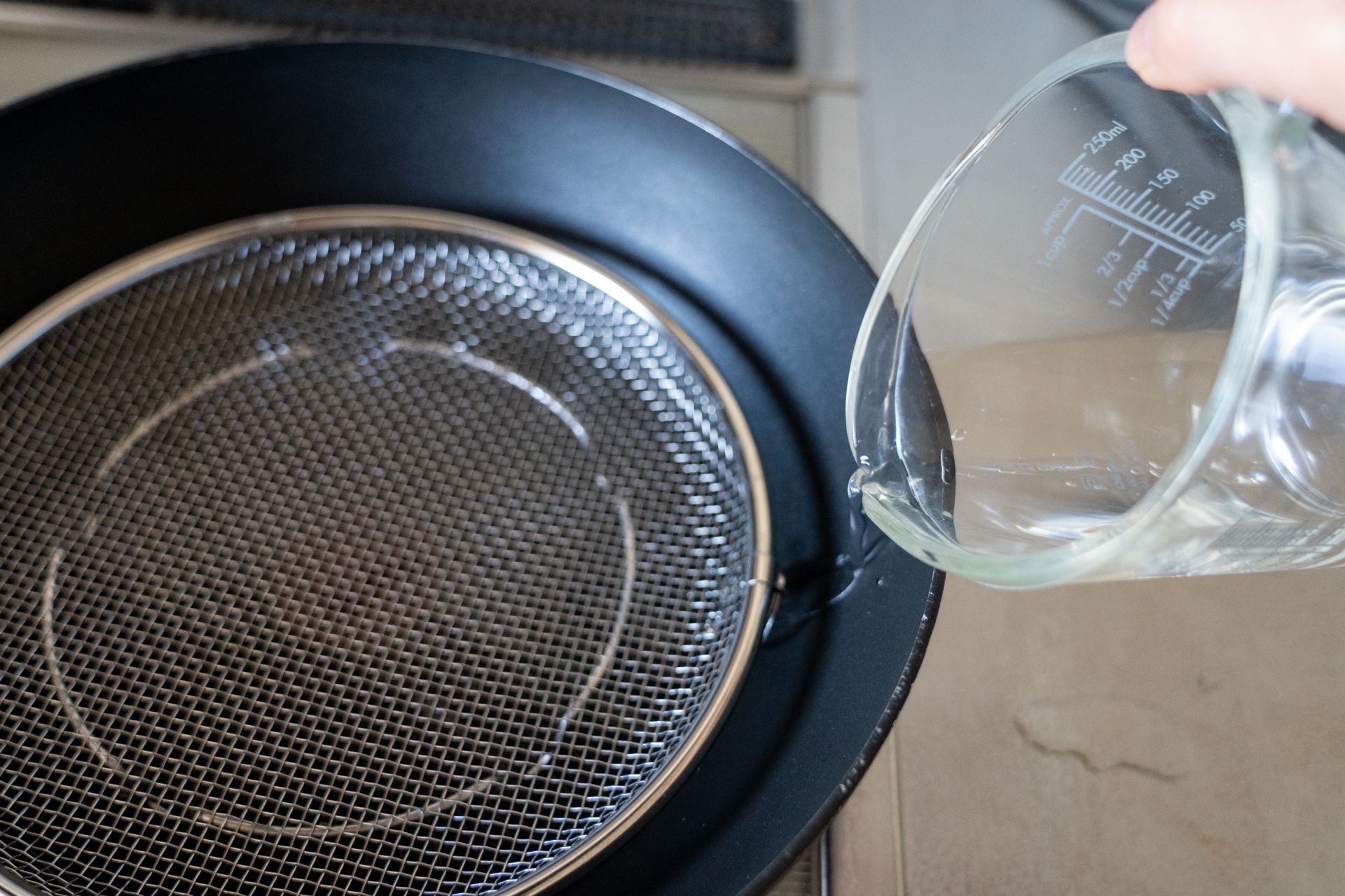 ざるから水が溢れない程度の水をフライパンに入れる