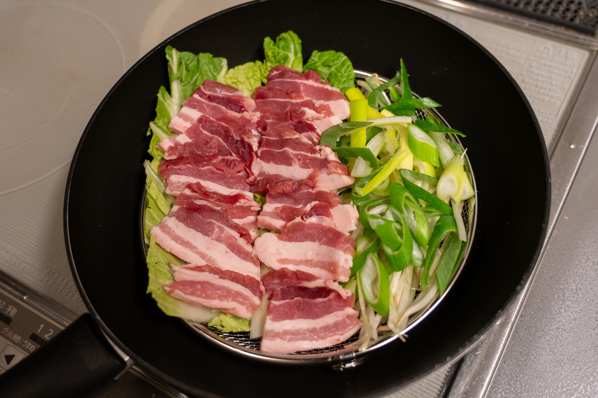 白菜やモヤシを敷いた上に豚バラブロック肉をスライスして蒸す