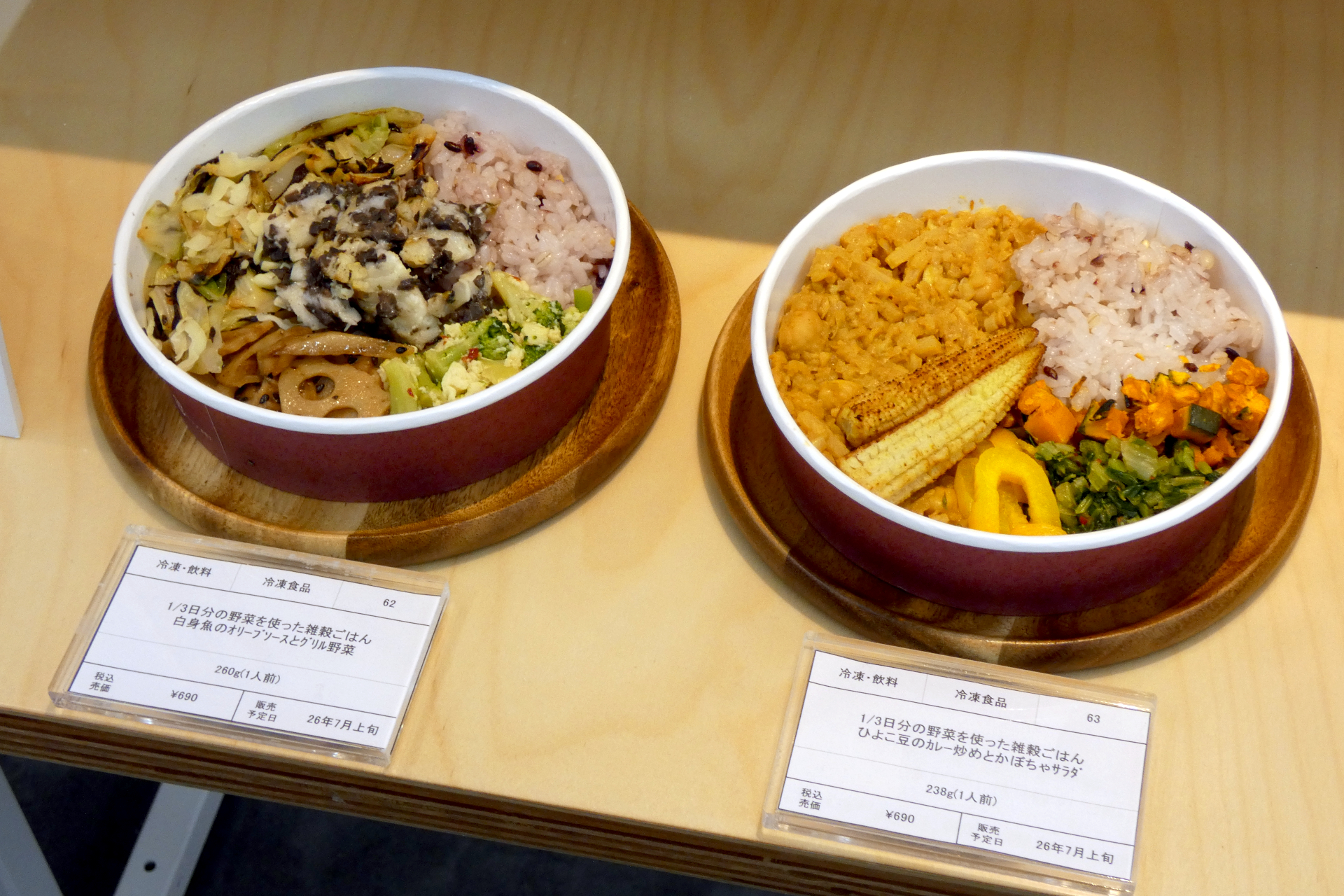 （左から）「1/3日分の野菜を使った雑穀ごはん 白身魚のオリーブソースとグリル野菜」（690円、7月下旬発売）、「1/3日分の野菜を使った雑穀ごはん ひよこ豆のカレー炒めとかぼちゃサラダ」（690円、7月下旬発売）