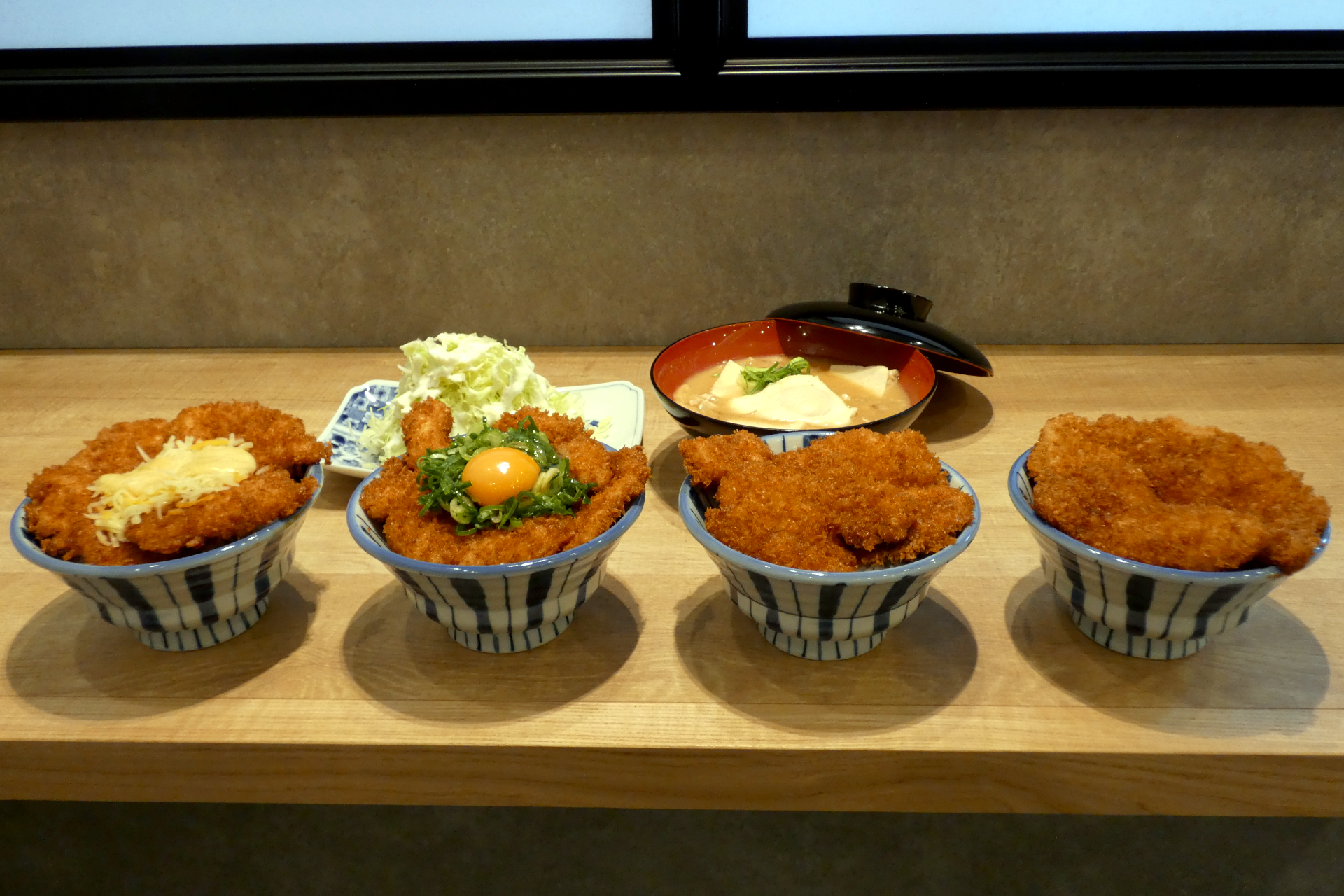 （手前左から）「鶏たれかつ丼」4枚＋チーズ、「鶏たれかつ丼」4枚＋ネギ玉、「鶏たれかつ丼」4枚、「豚たれかつ丼」3枚、（奥左から）キャベツサラダ、豚汁