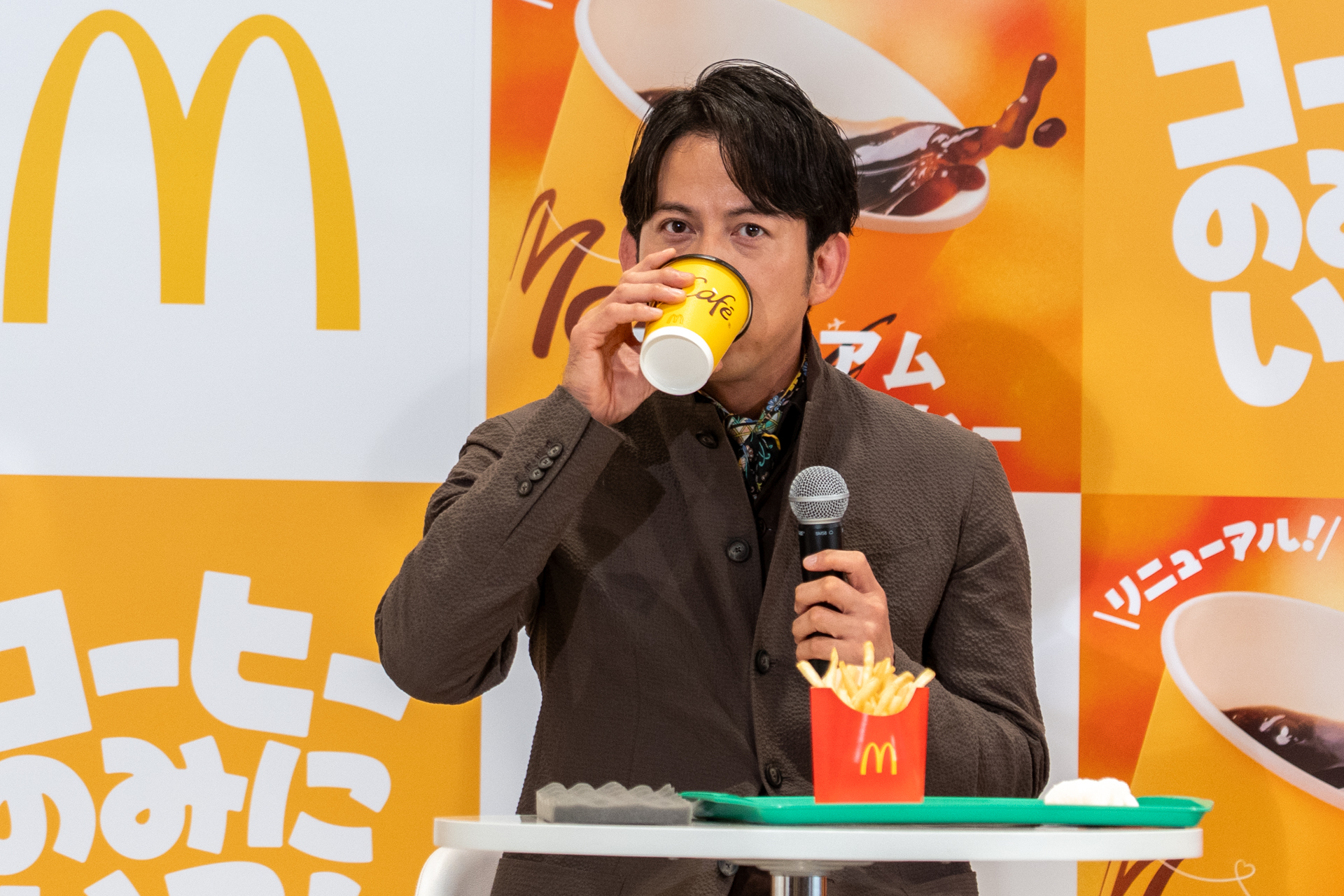 リニューアルしたプレミアムローストコーヒーを試飲する岡田准一さん