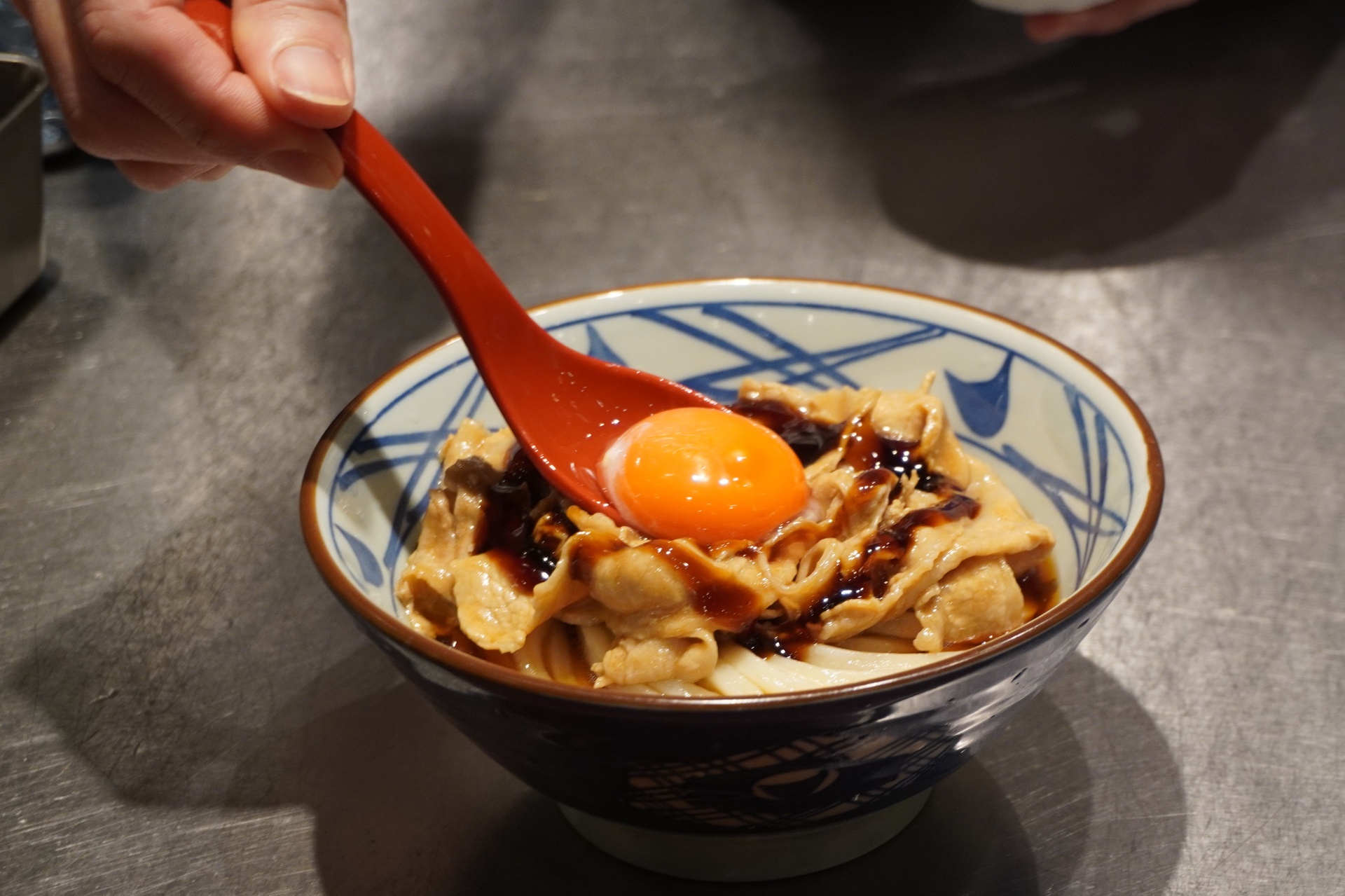 甘辛醤油ダレをかけて、中央に卵黄をのせる