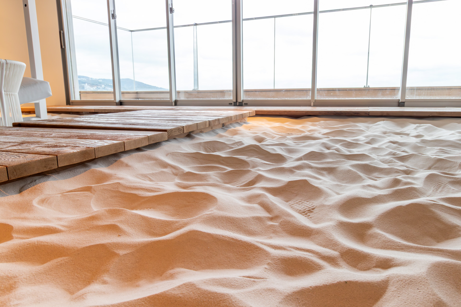 オーストラリアから取り寄せた真っ白な砂。店内は入口で靴を脱いで、スリッパや裸足で過ごすことができる