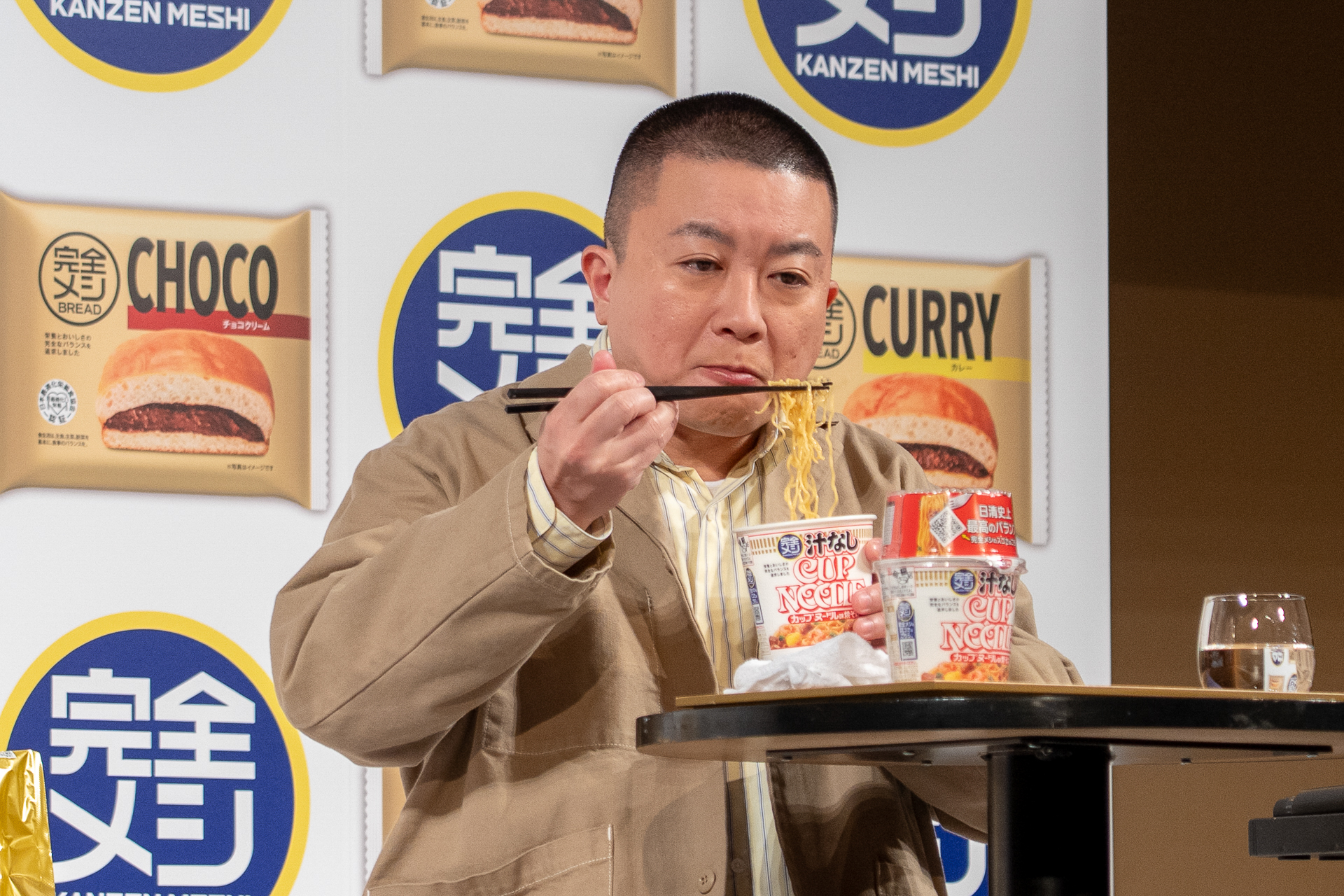 「完全メシ 汁なしカップヌードル」を食べる松尾さん