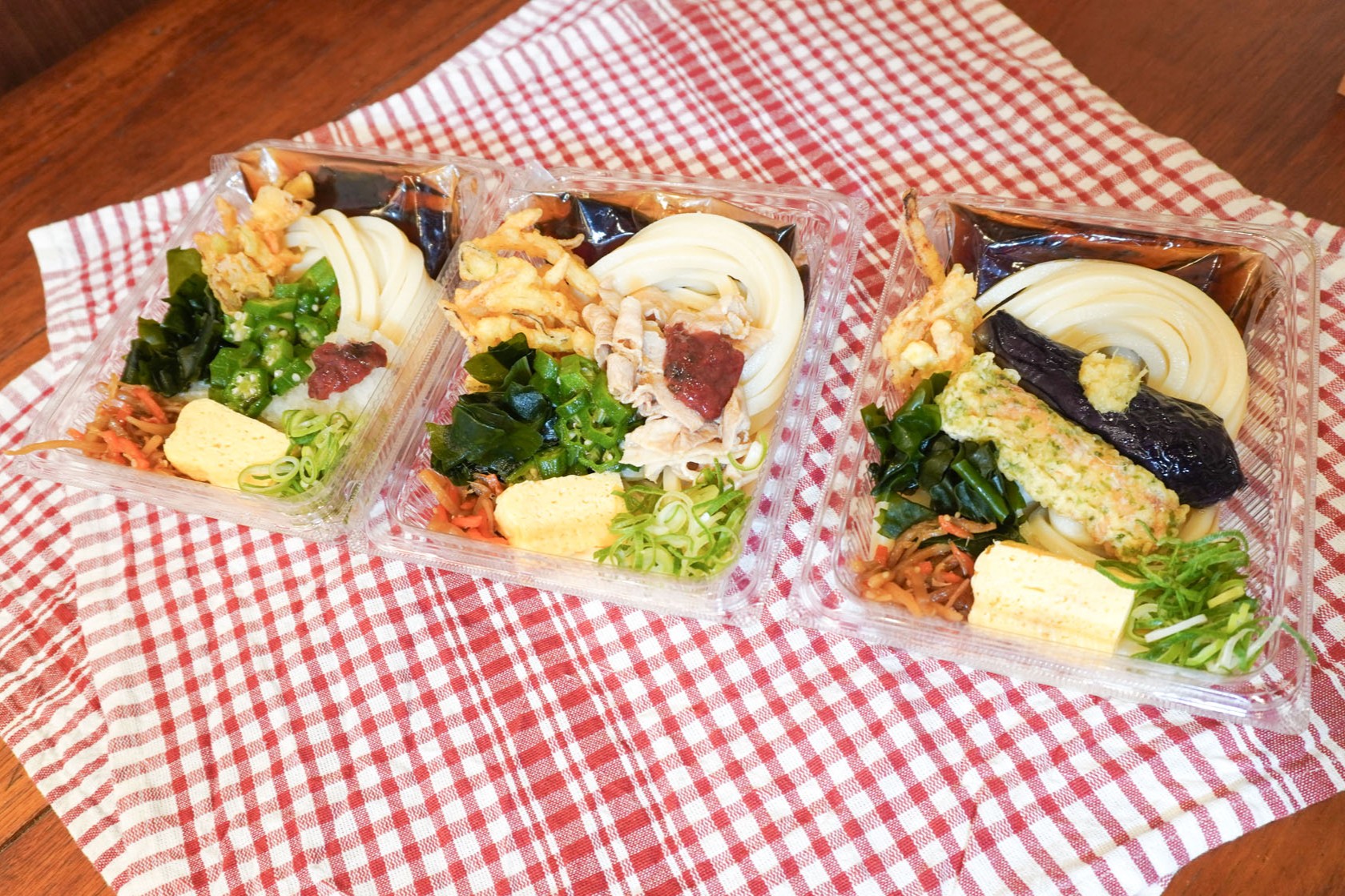 （右から）「なすの揚げびたしと定番おかずのうどん弁当」「豚しゃぶと梅オクラうどん弁当」「梅おろしオクラうどん弁当」
