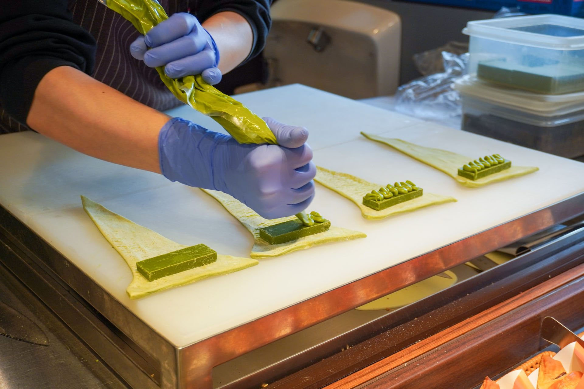 生地の上に抹茶のチョコレートプレートを置き、その上に抹茶クリームを絞る