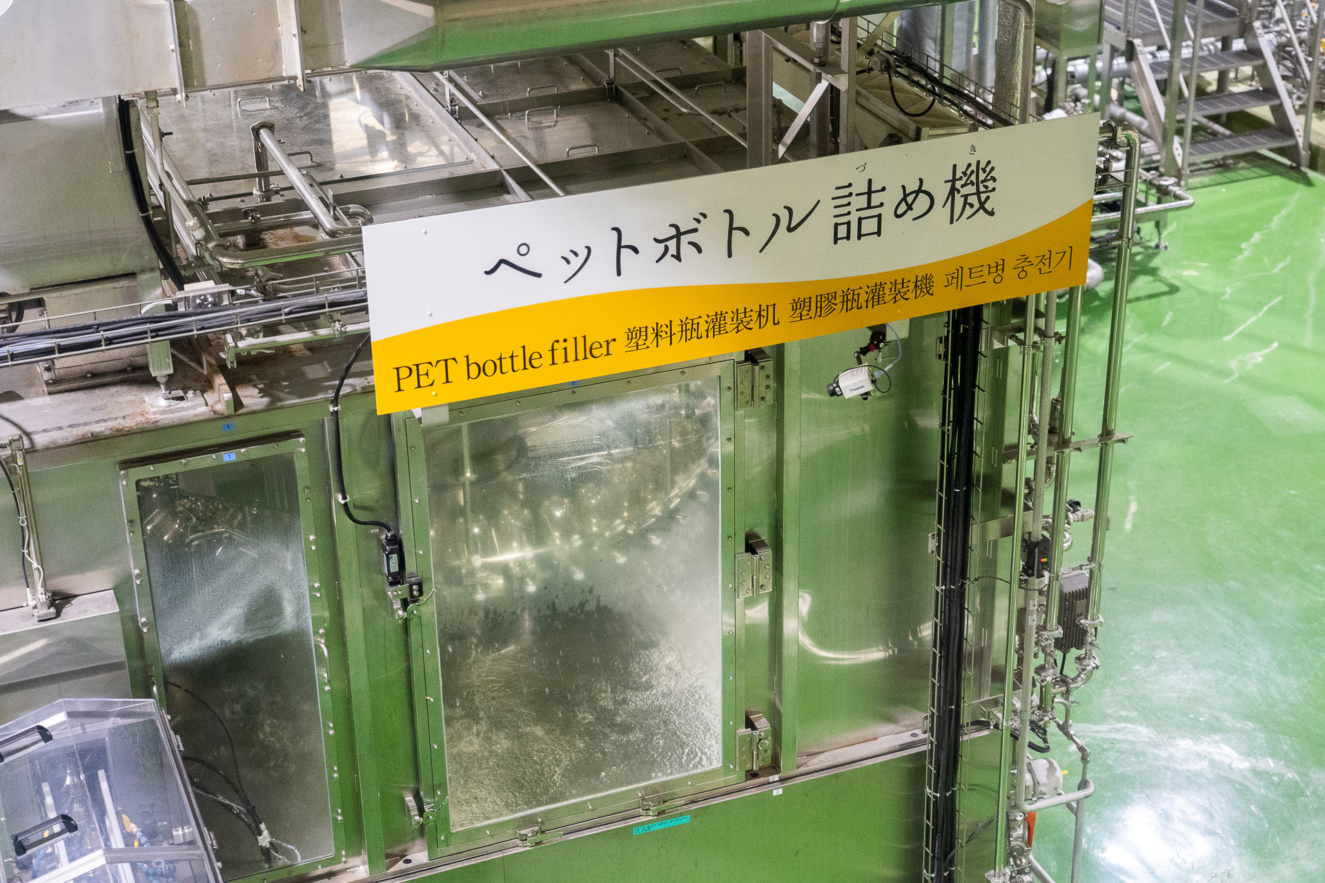 ビールがペットボトルに詰められるパッキングラインをガラス越しに見学