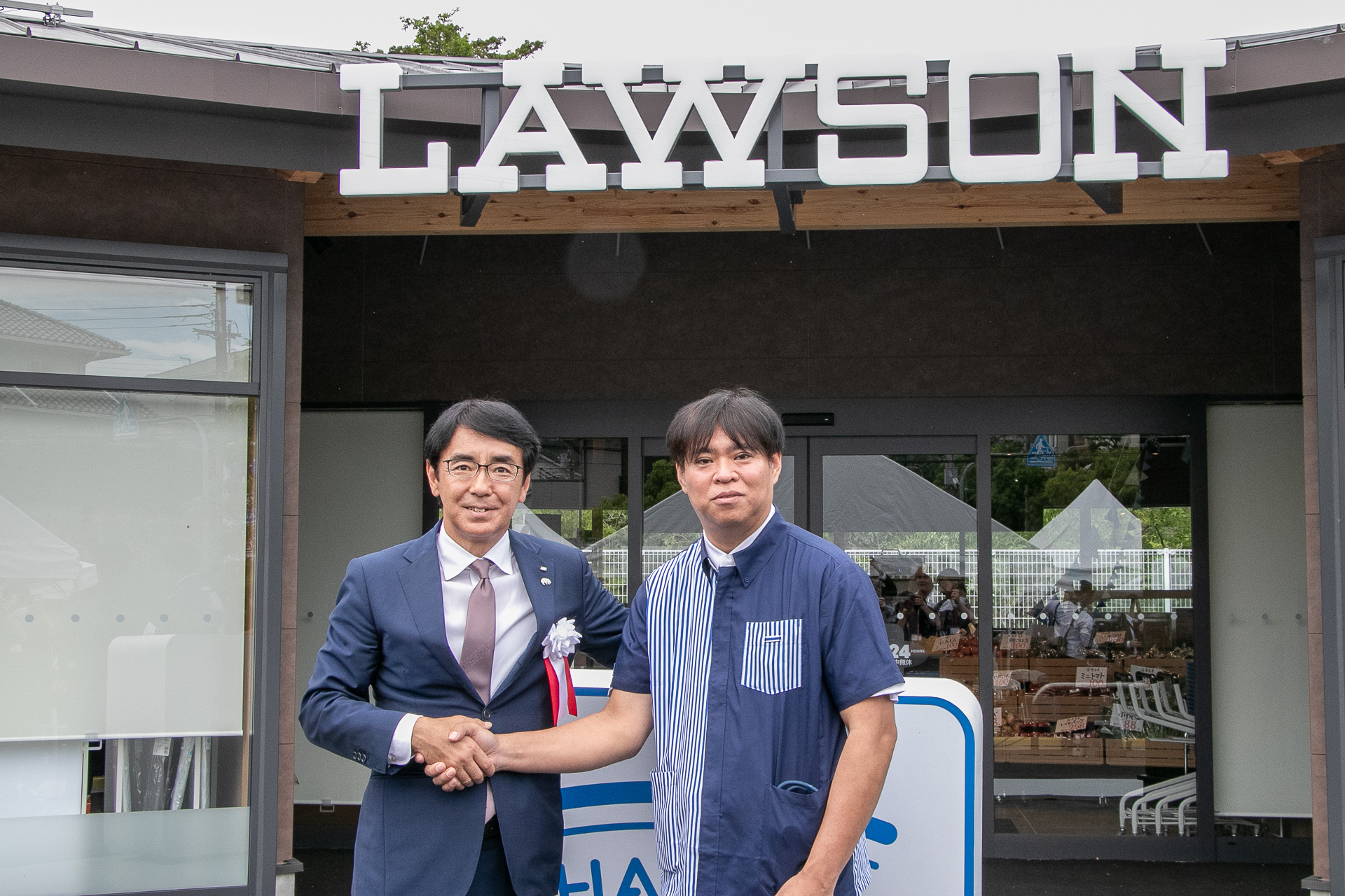 株式会社ローソン 代表取締役社長 竹増貞信氏（左）とハッピーローソンタウン池田伏尾台店 オーナー 當銘偉哲氏（右）